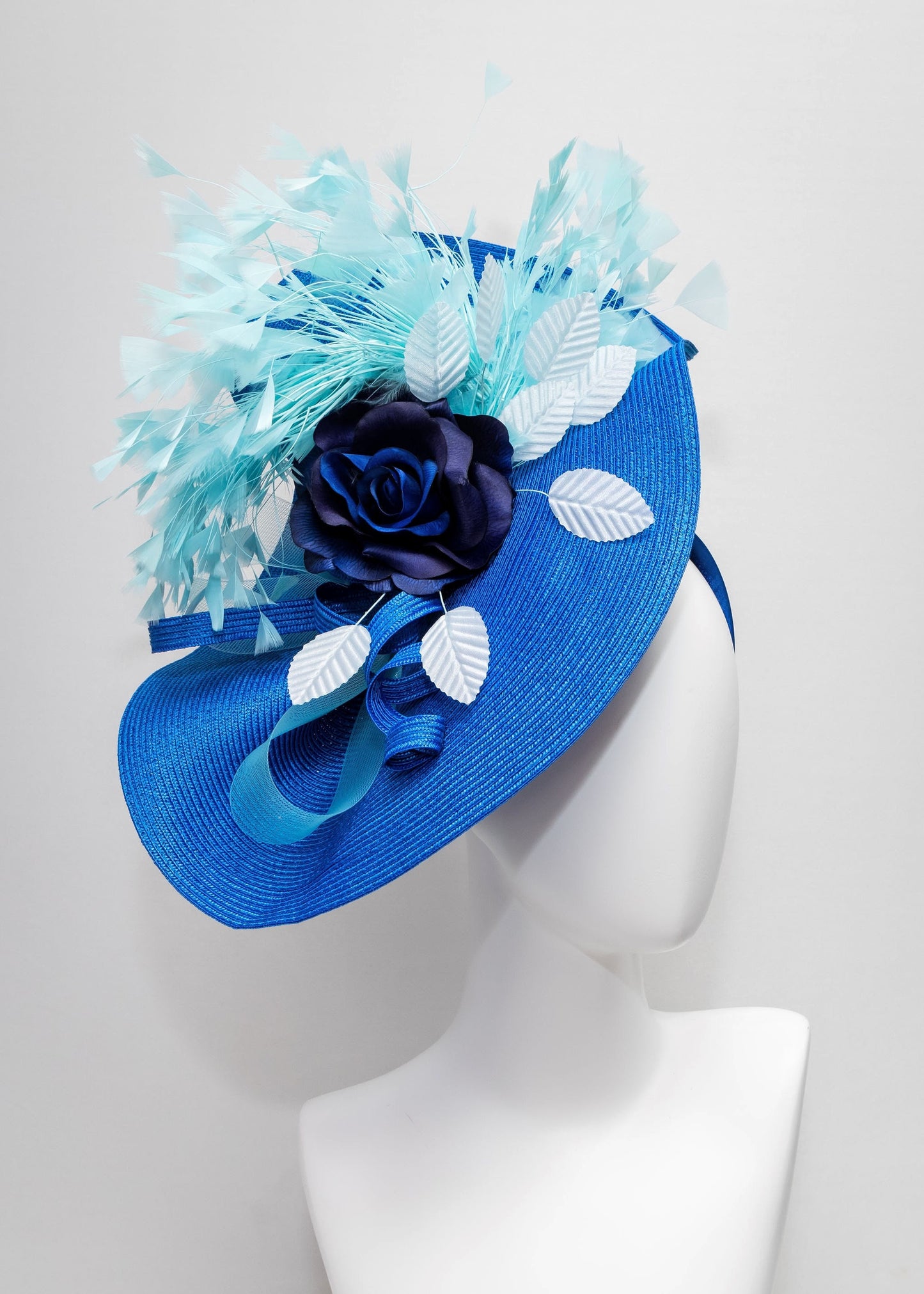 kentucky derby hat fascinator royal blue woven base with navy rose flower light blue leaves aqua turquoise blue feathers