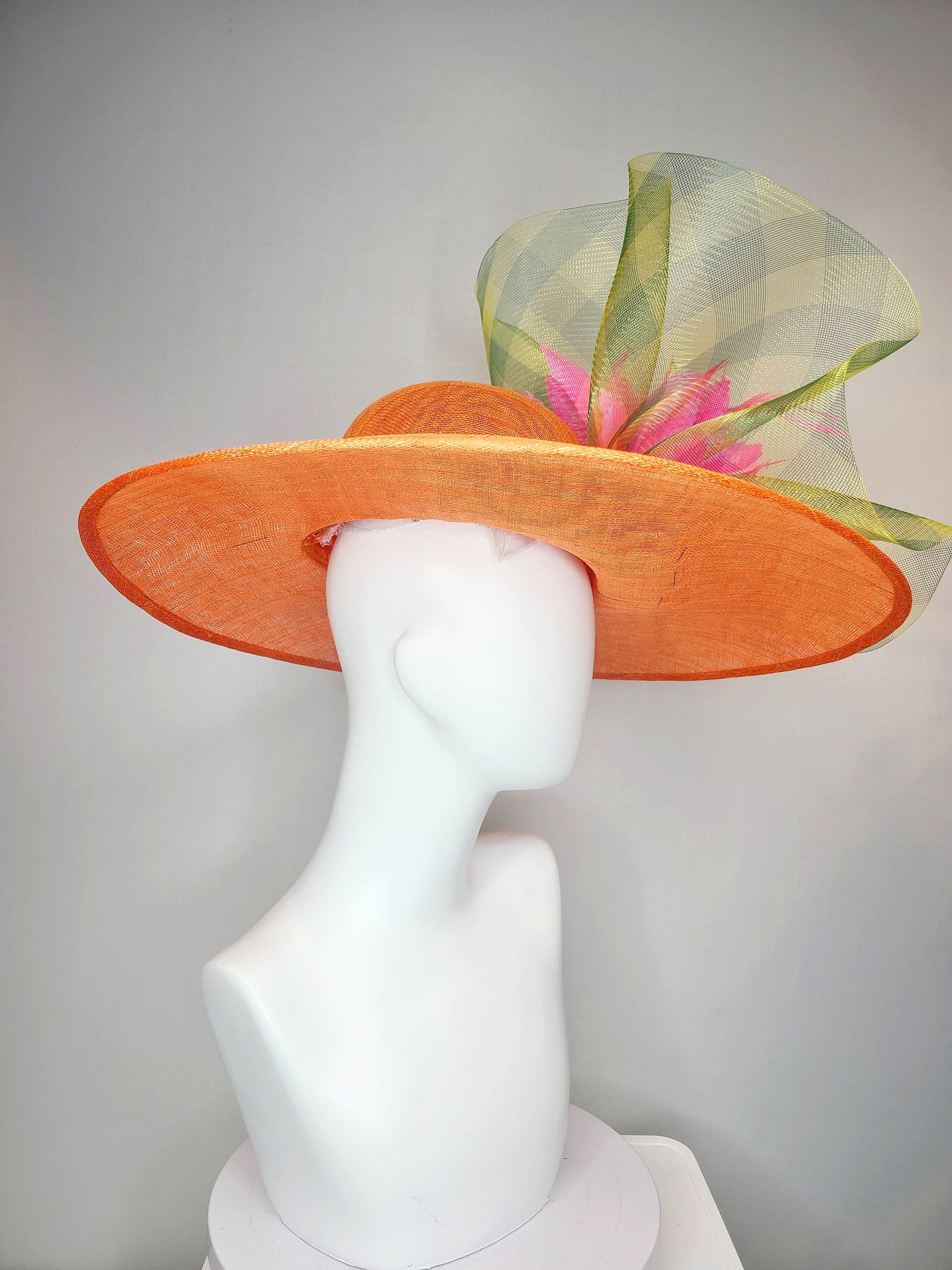 kentucky derby hat large wide brim sinamay orange hat with large pink feather pouf decor with green gingham plaid crinoline