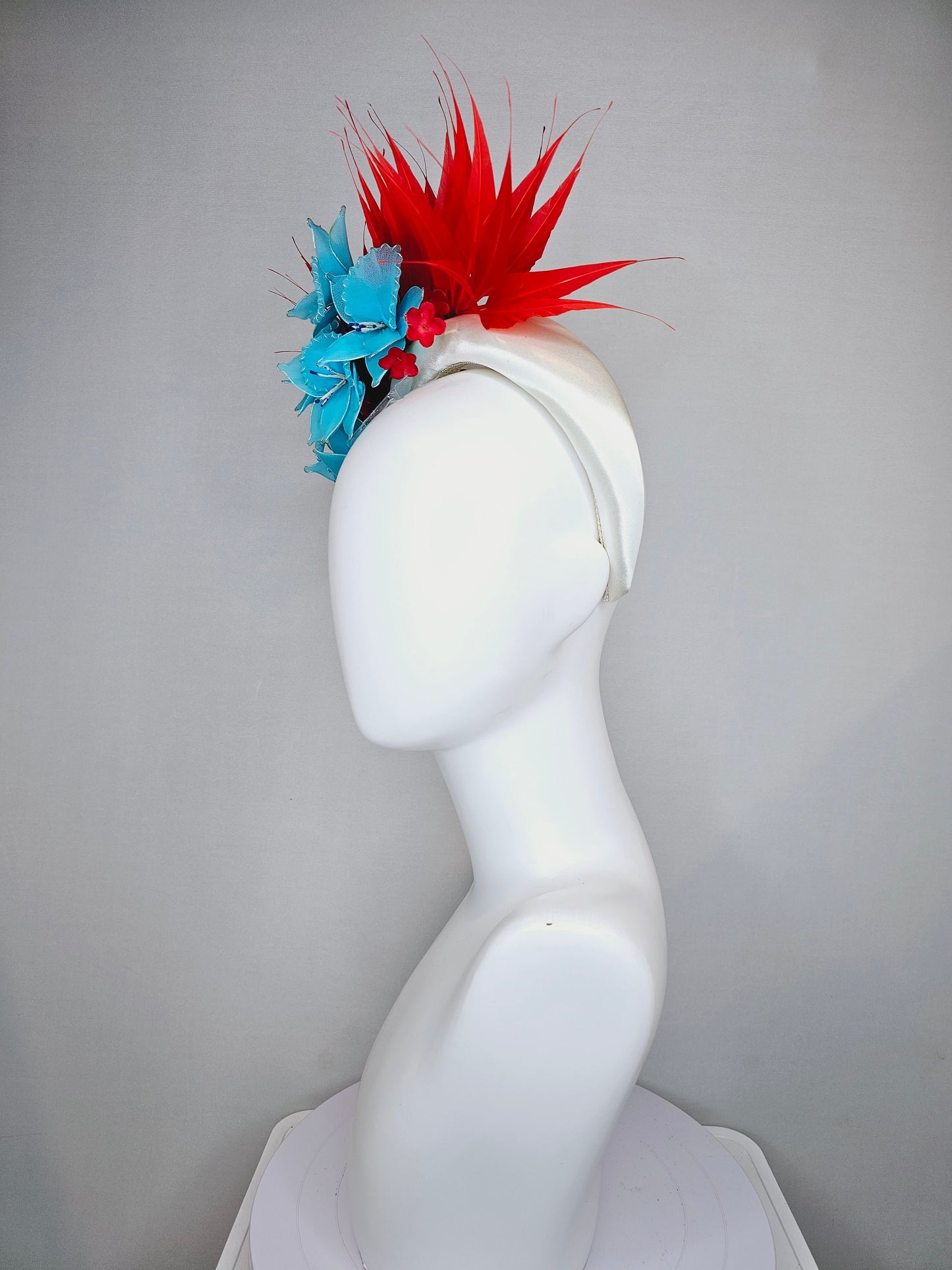 kentucky derby hat fascinator white satin padded headband with bright red spike feathers and bright turquoise blue flowers red flower accent
