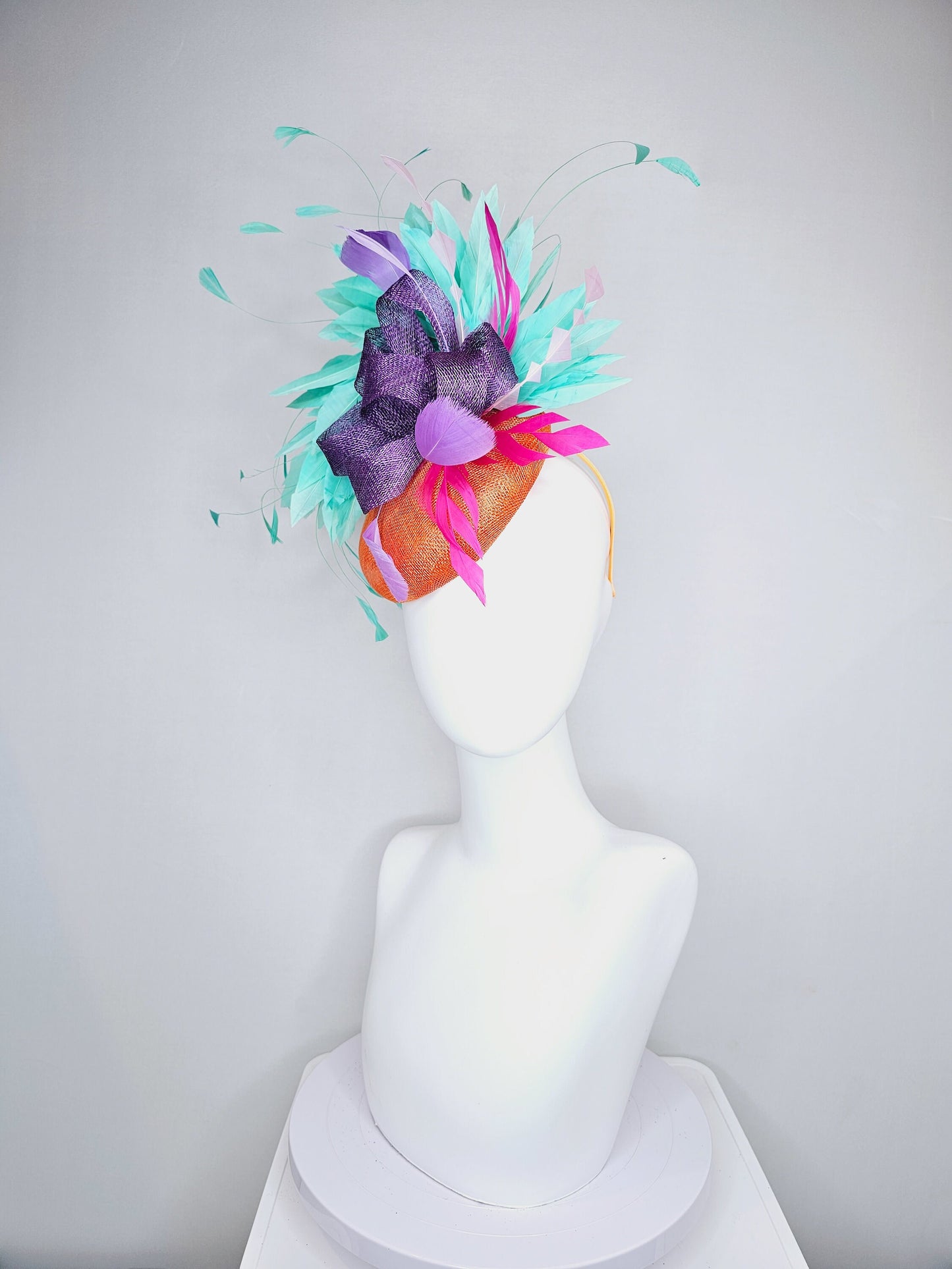kentucky derby hat fascinator orange sinamay with mint green feathers with purple sinamay bow and hot pink feather accent