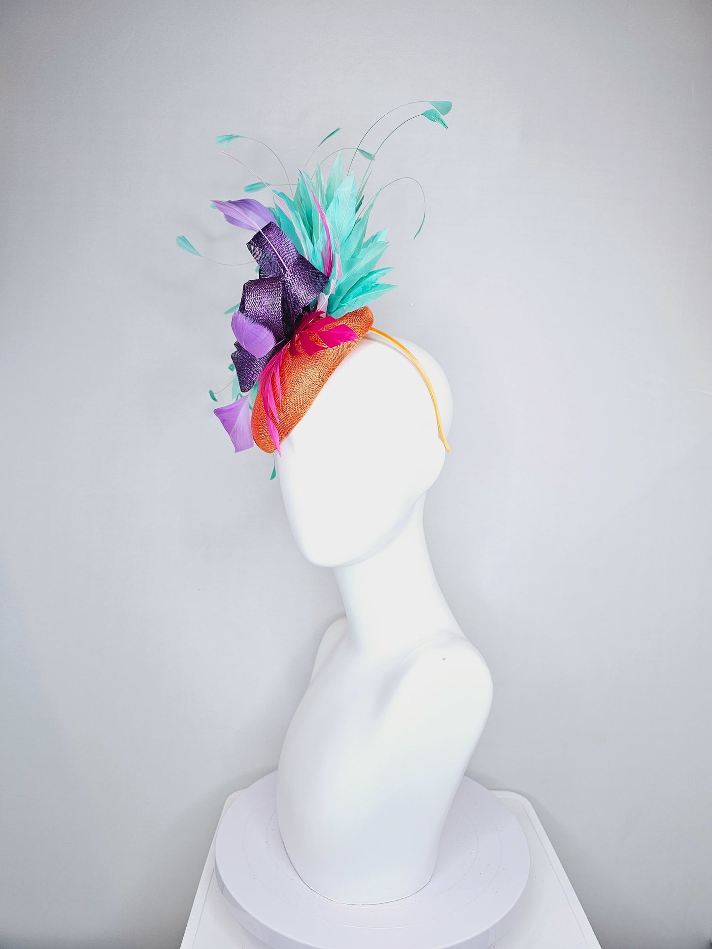 kentucky derby hat fascinator orange sinamay with mint green feathers with purple sinamay bow and hot pink feather accent