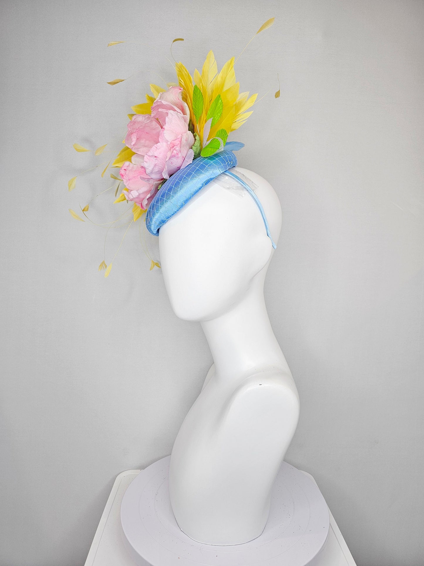 kentucky derby hat fascinator light blue satin with large light pink flowers bright green leaves and yellow feathers