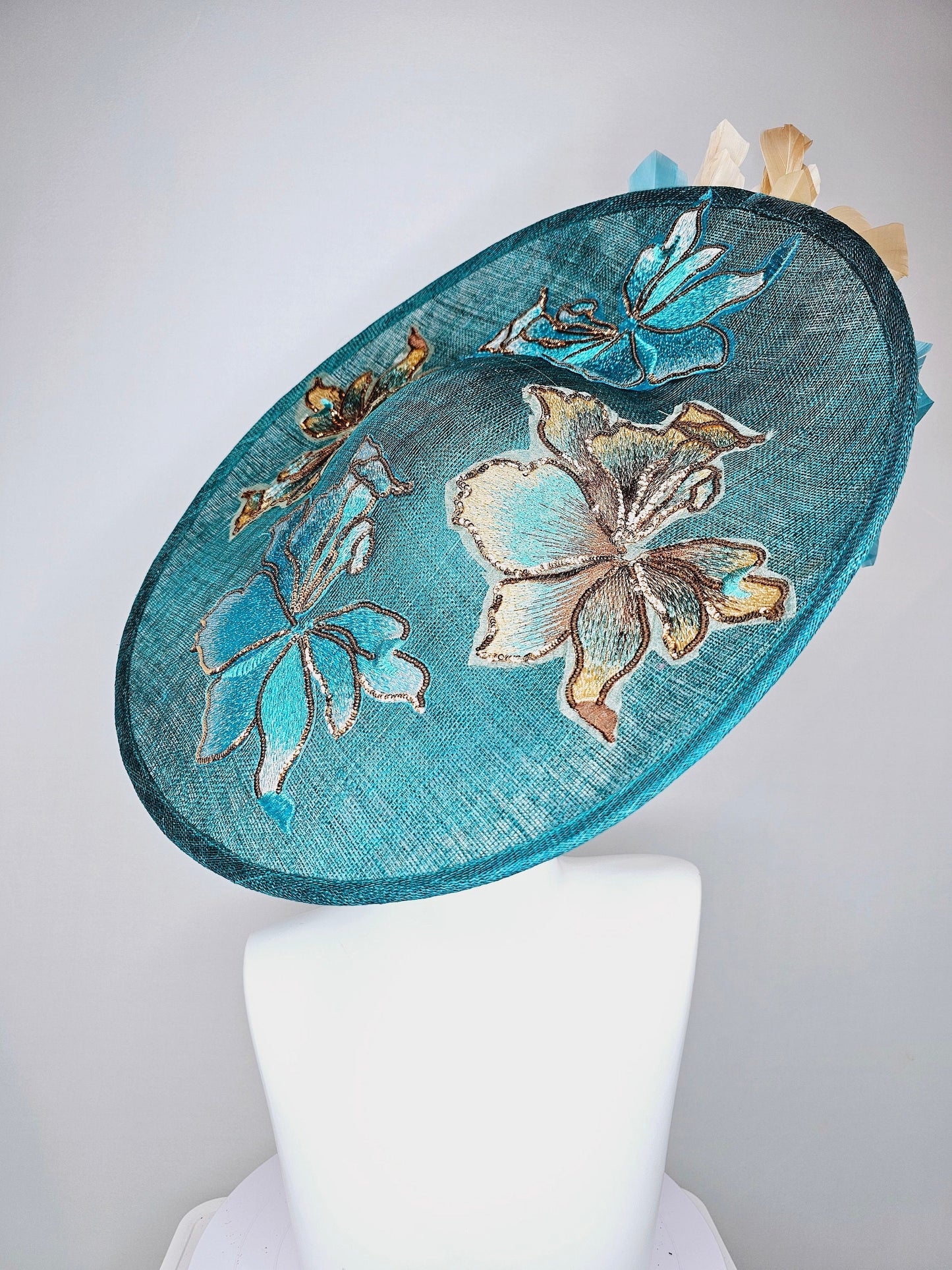 kentucky derby hat fascinator teal blue sinamay saucer with gold and teal peacock blue green feathers and teal gold embroidered flowers