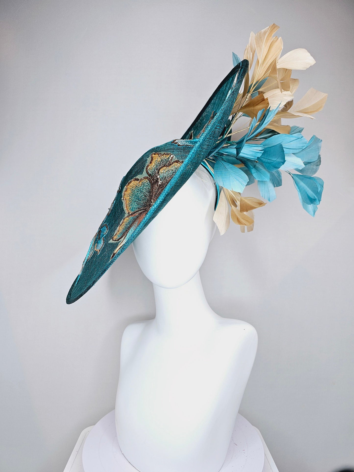 kentucky derby hat fascinator teal blue sinamay saucer with gold and teal peacock blue green feathers and teal gold embroidered flowers