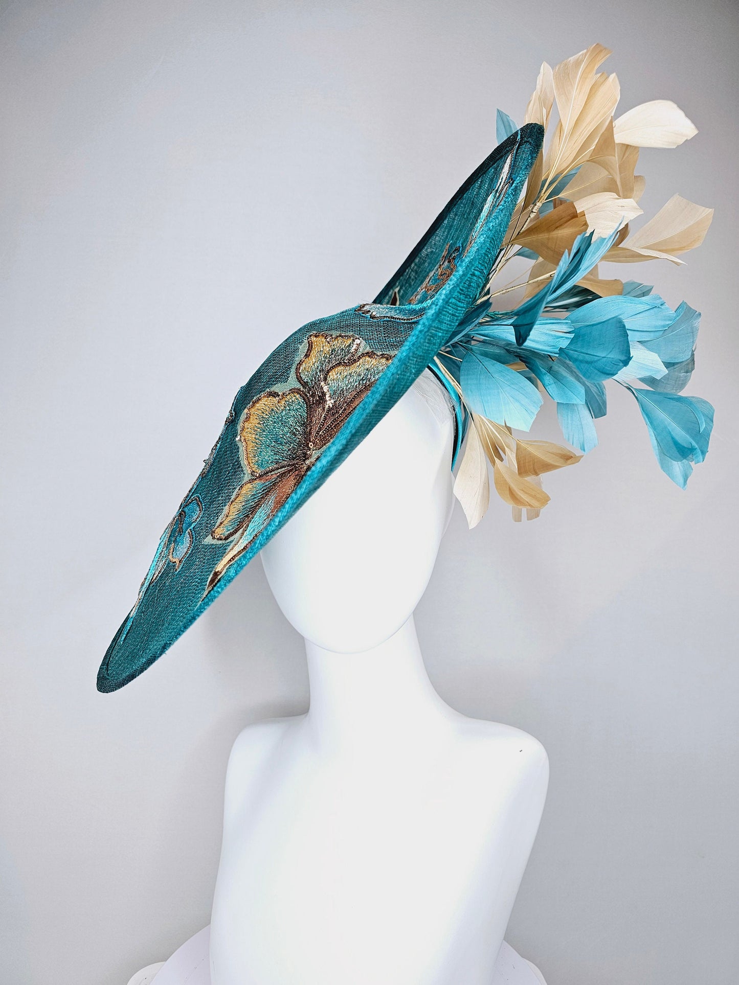 kentucky derby hat fascinator teal blue sinamay saucer with gold and teal peacock blue green feathers and teal gold embroidered flowers