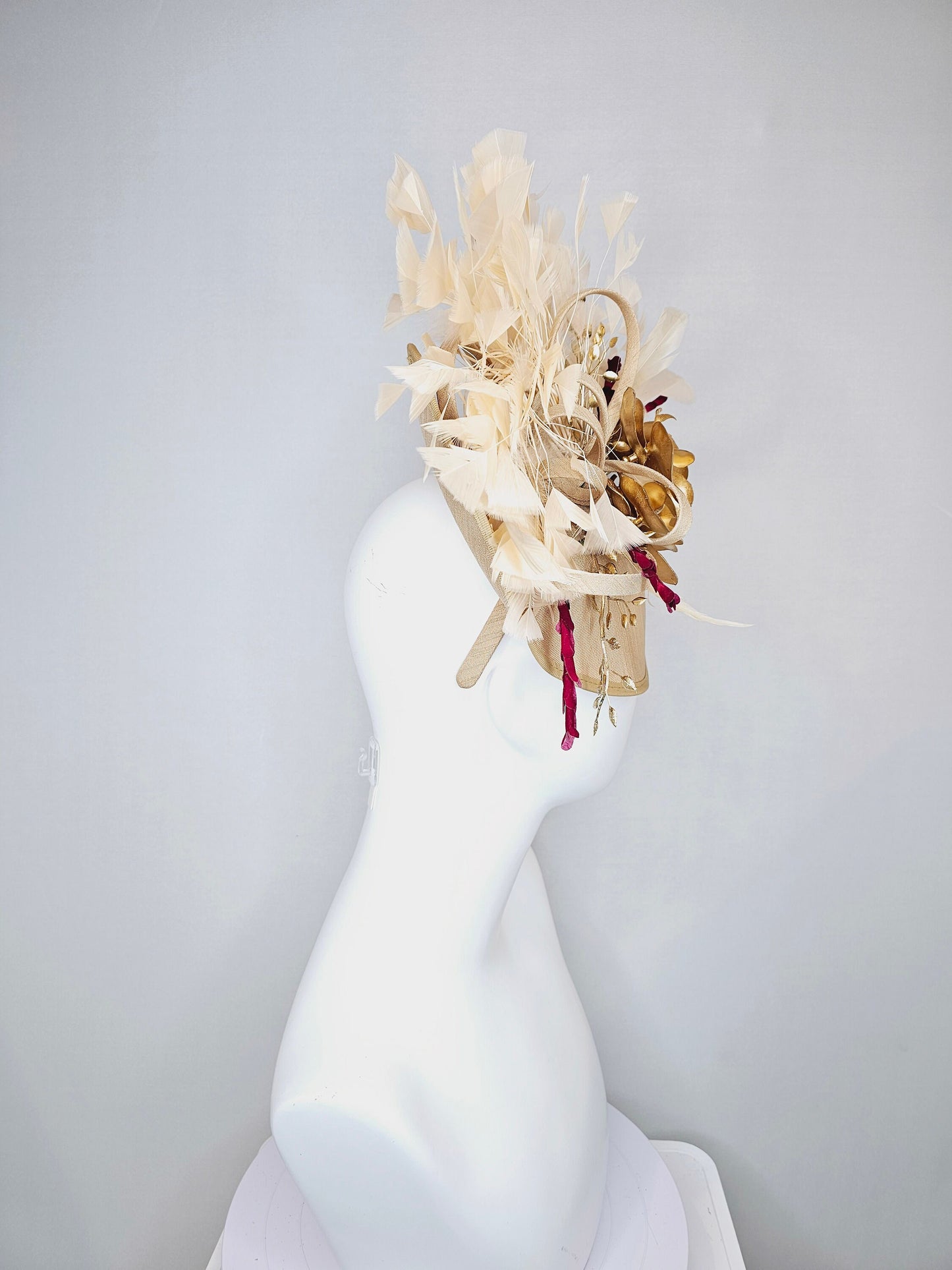 kentucky derby hat fascinator gold taupe beige shantung silk saucer with curls and gold orchids and light tan feathers with burgundy stems