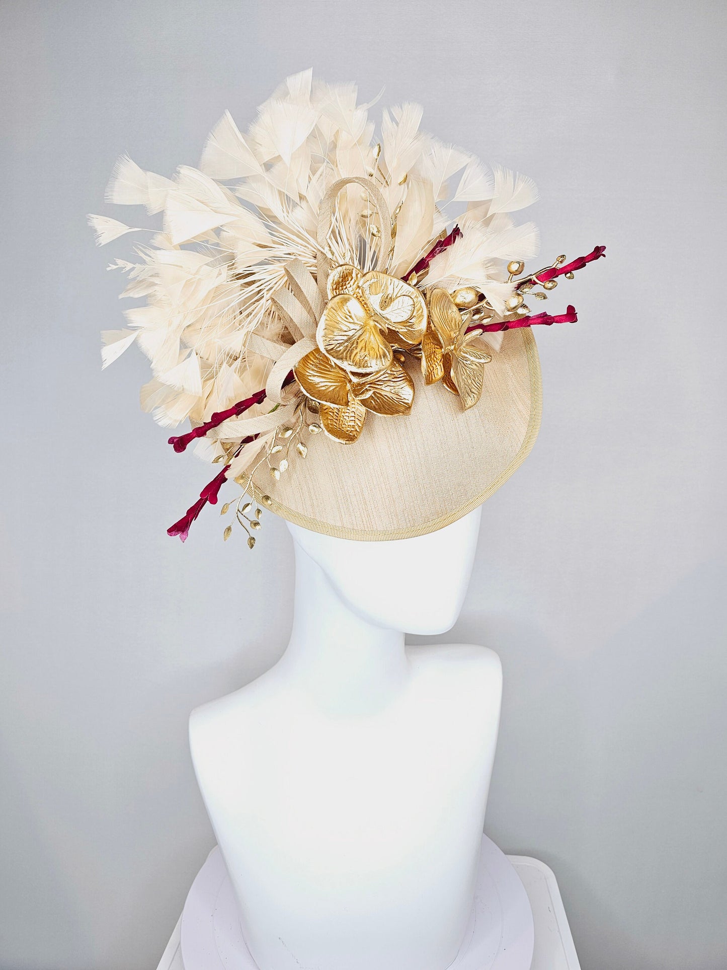 kentucky derby hat fascinator gold taupe beige shantung silk saucer with curls and gold orchids and light tan feathers with burgundy stems