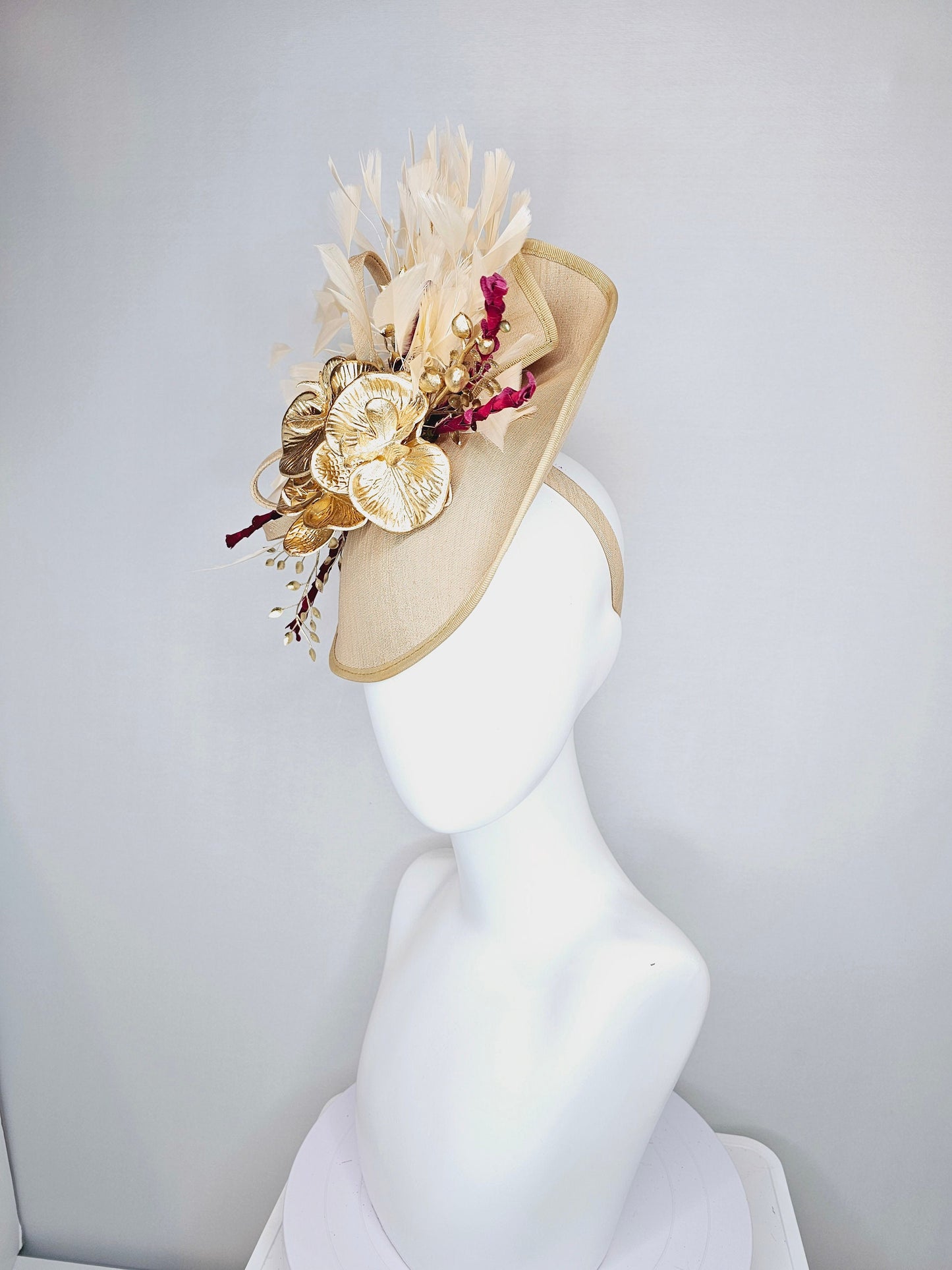 kentucky derby hat fascinator gold taupe beige shantung silk saucer with curls and gold orchids and light tan feathers with burgundy stems