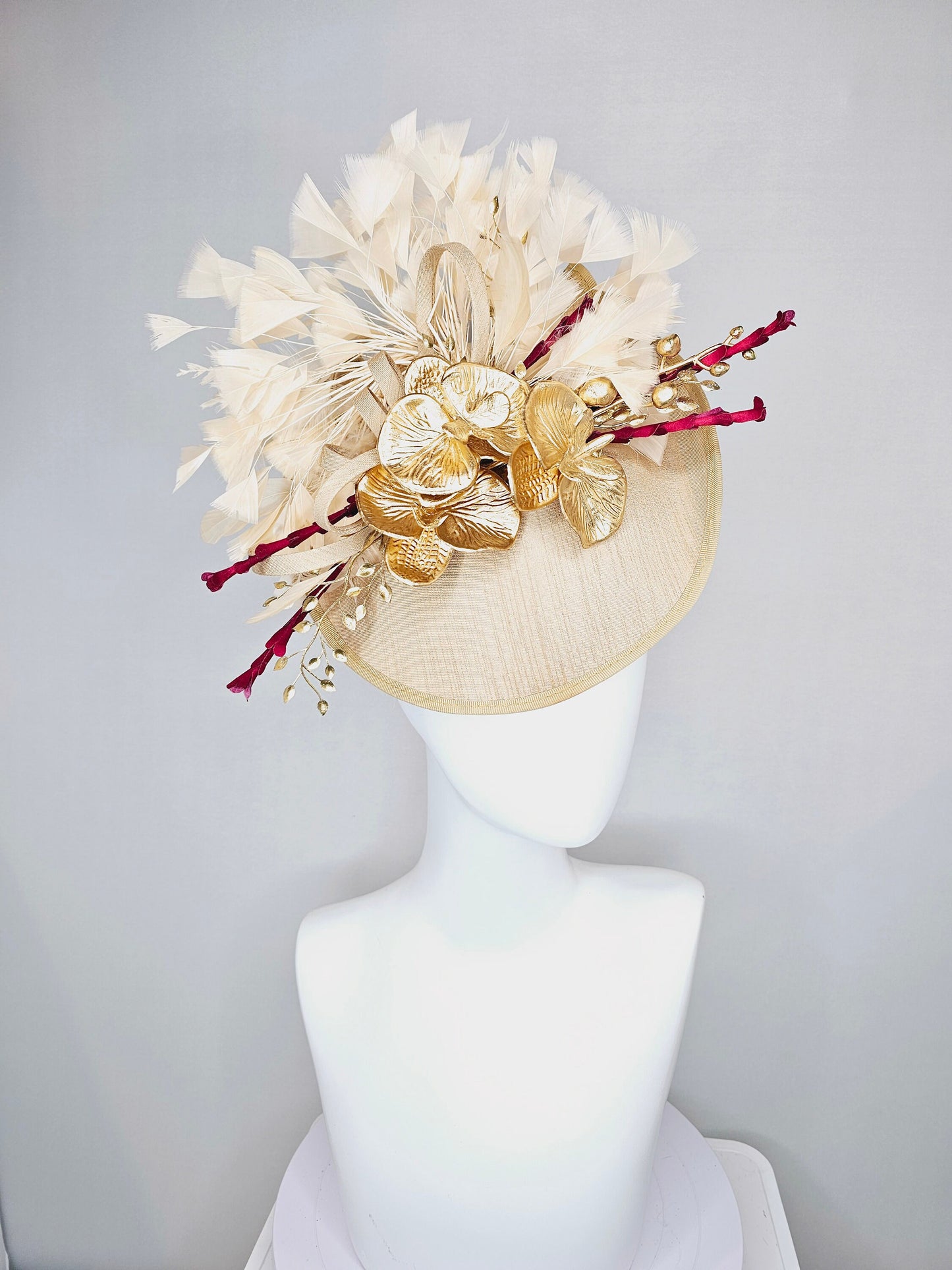 kentucky derby hat fascinator gold taupe beige shantung silk saucer with curls and gold orchids and light tan feathers with burgundy stems