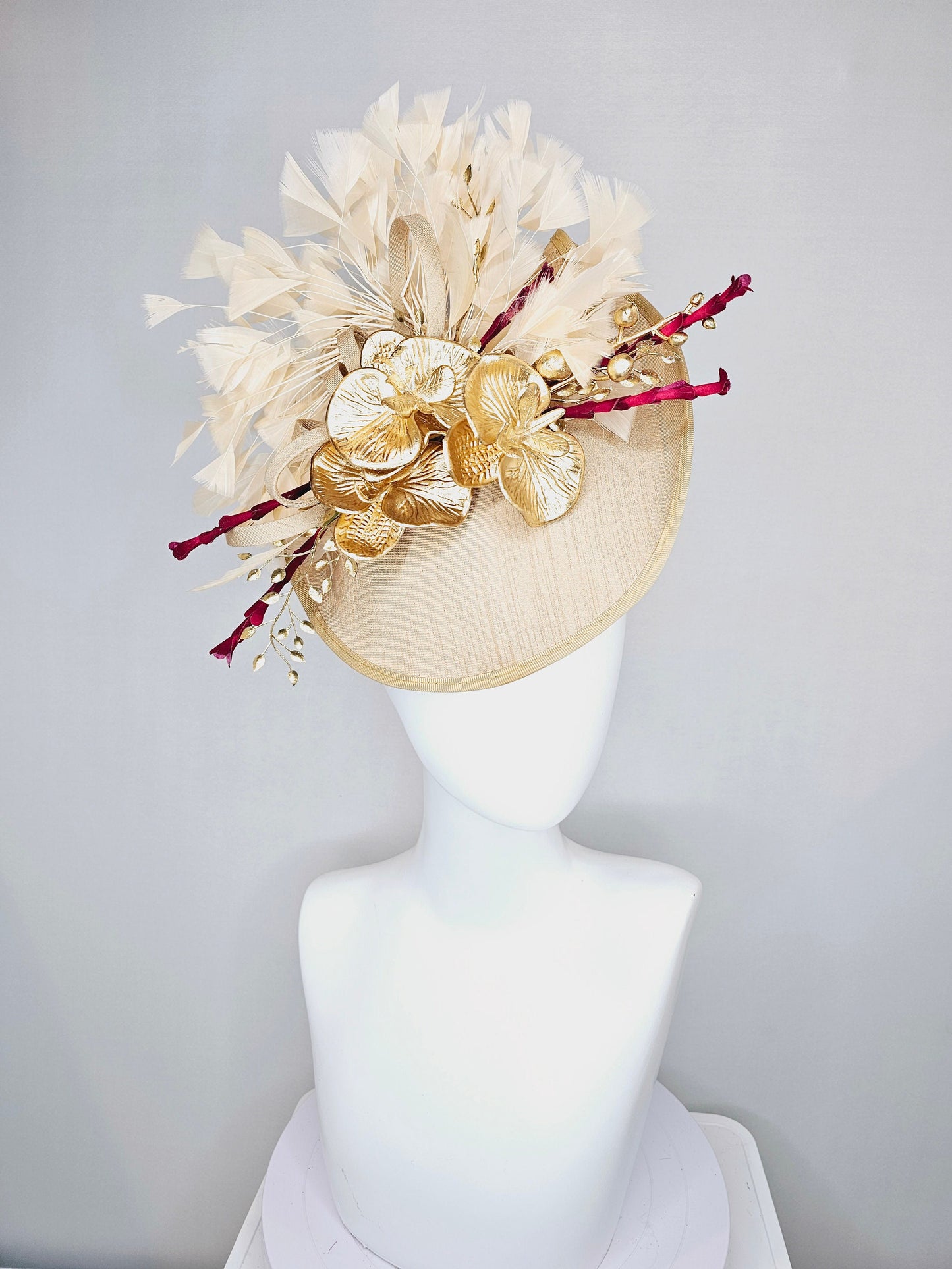kentucky derby hat fascinator gold taupe beige shantung silk saucer with curls and gold orchids and light tan feathers with burgundy stems