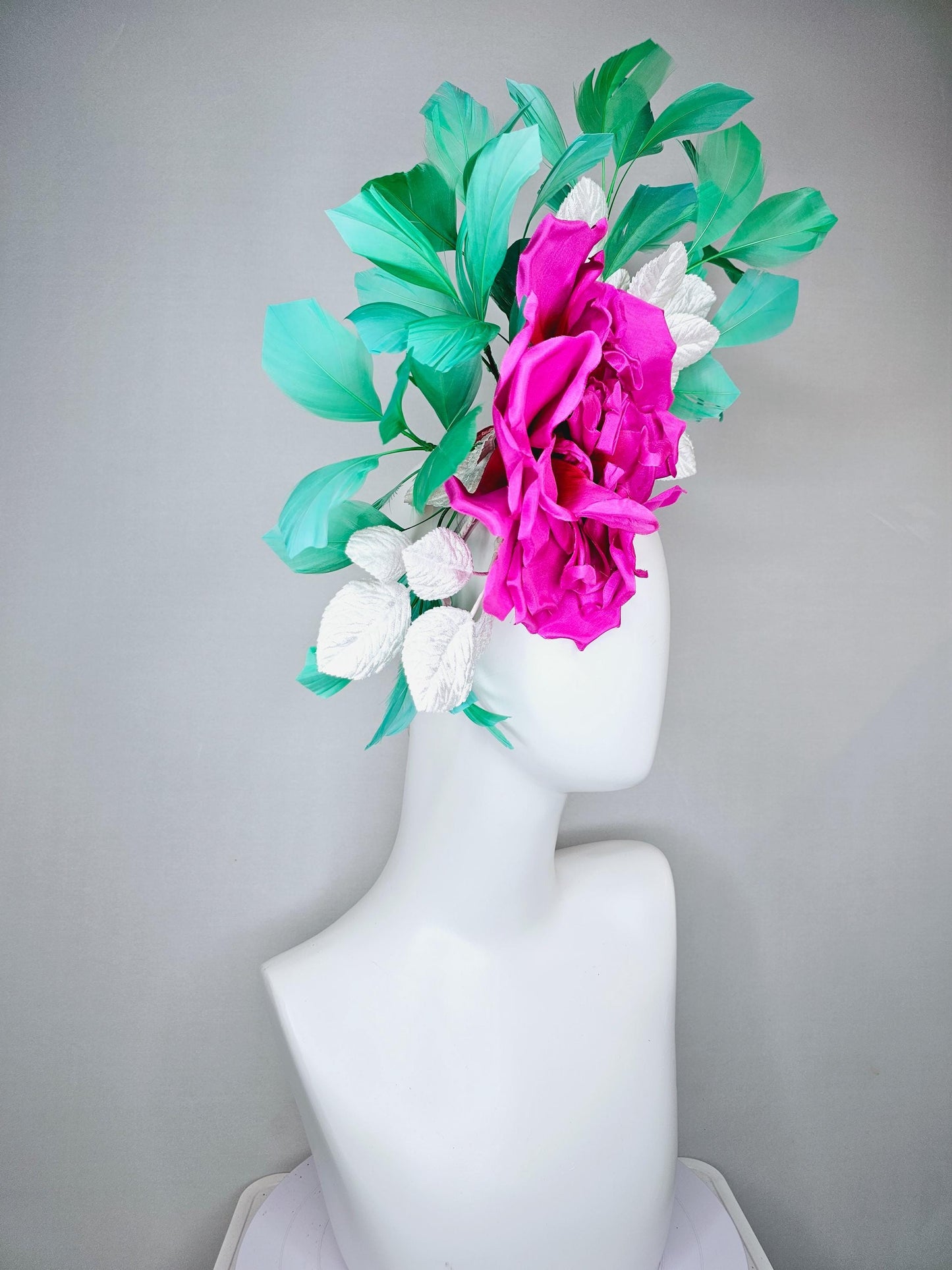 kentucky derby hat fascinator with bright pink fuchsia satin silk flower with white leaves and green branching feathers