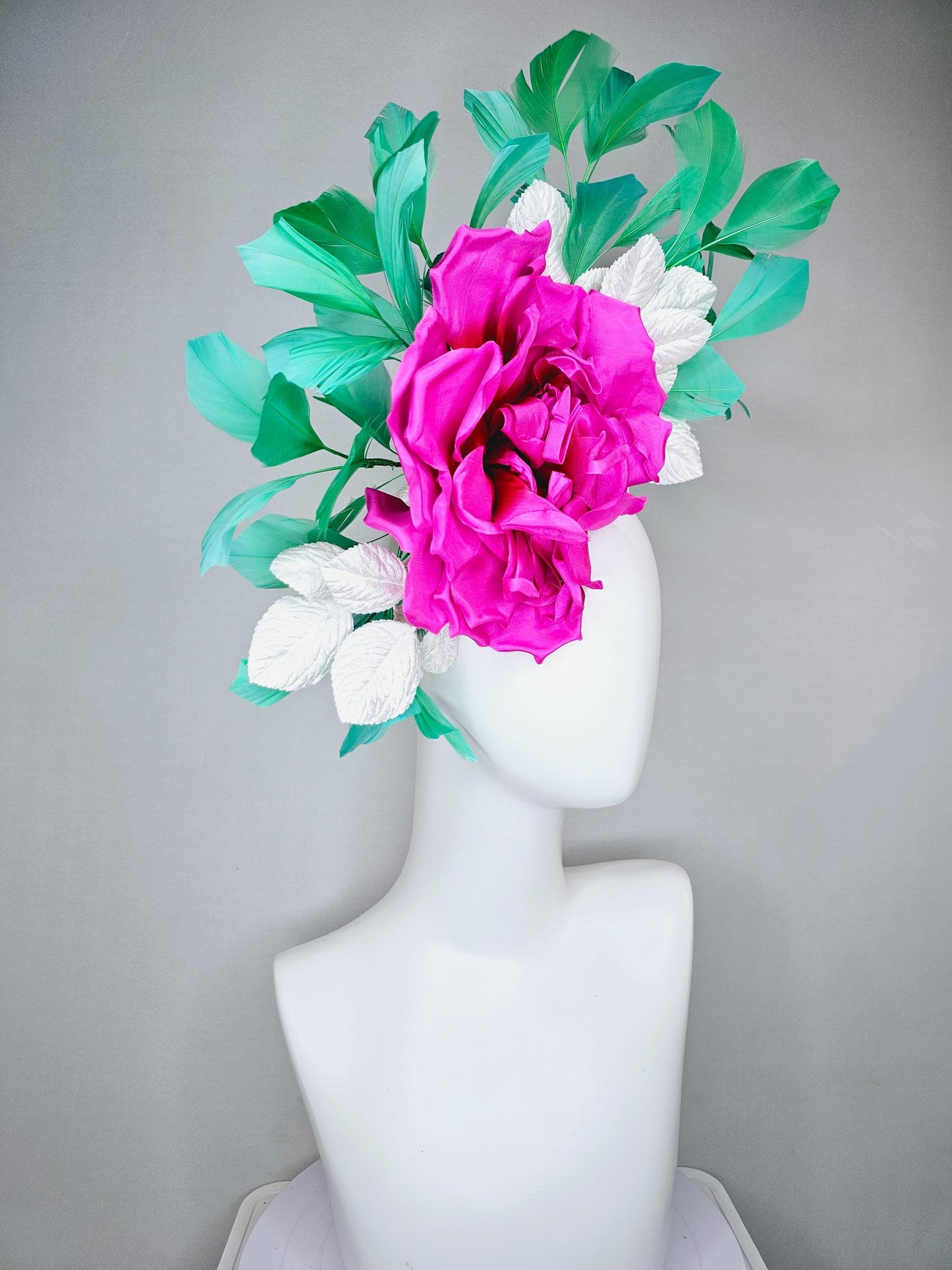 kentucky derby hat fascinator with bright pink fuchsia satin silk flower with white leaves and green branching feathers