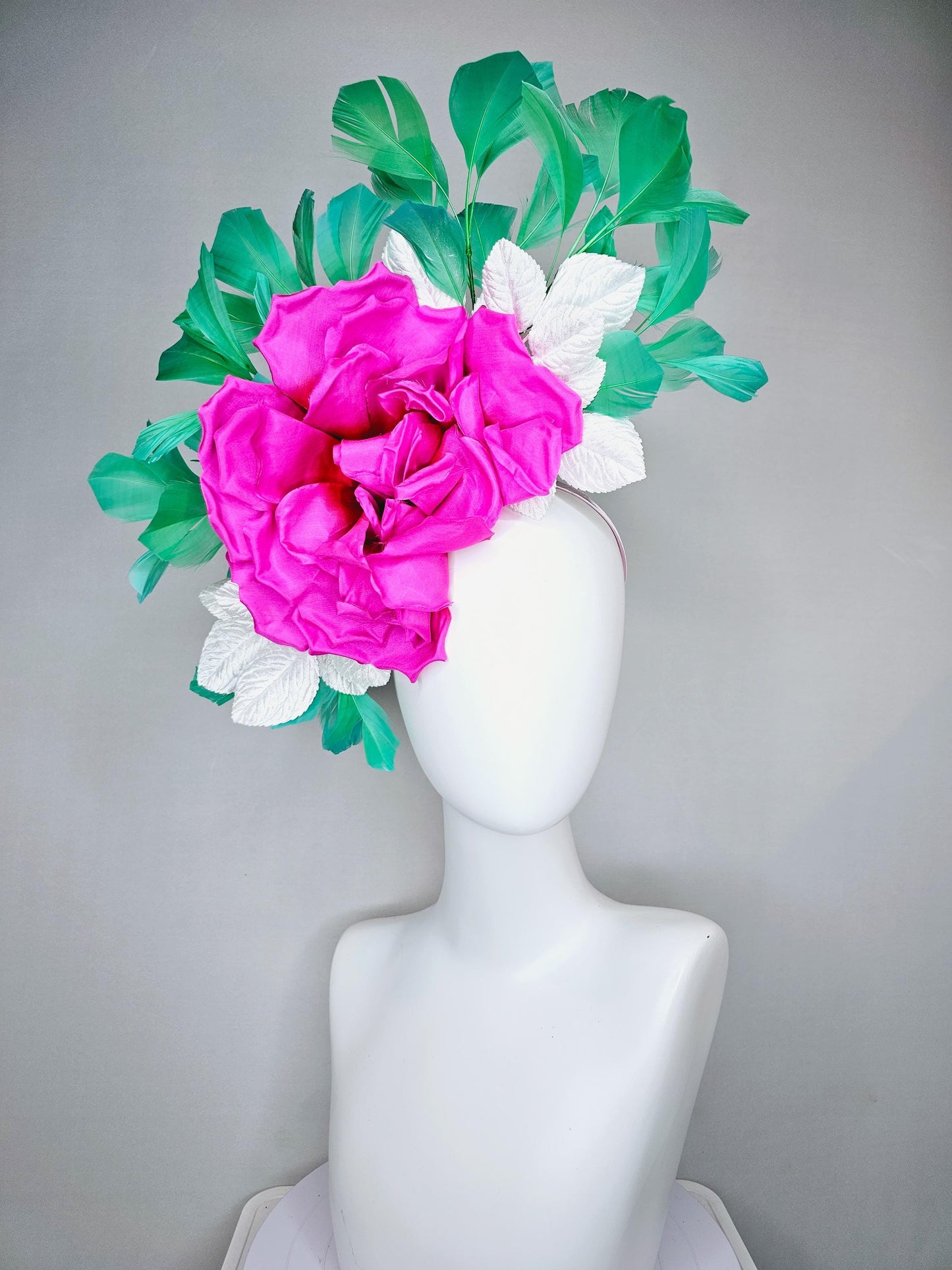 kentucky derby hat fascinator with bright pink fuchsia satin silk flower with white leaves and green branching feathers