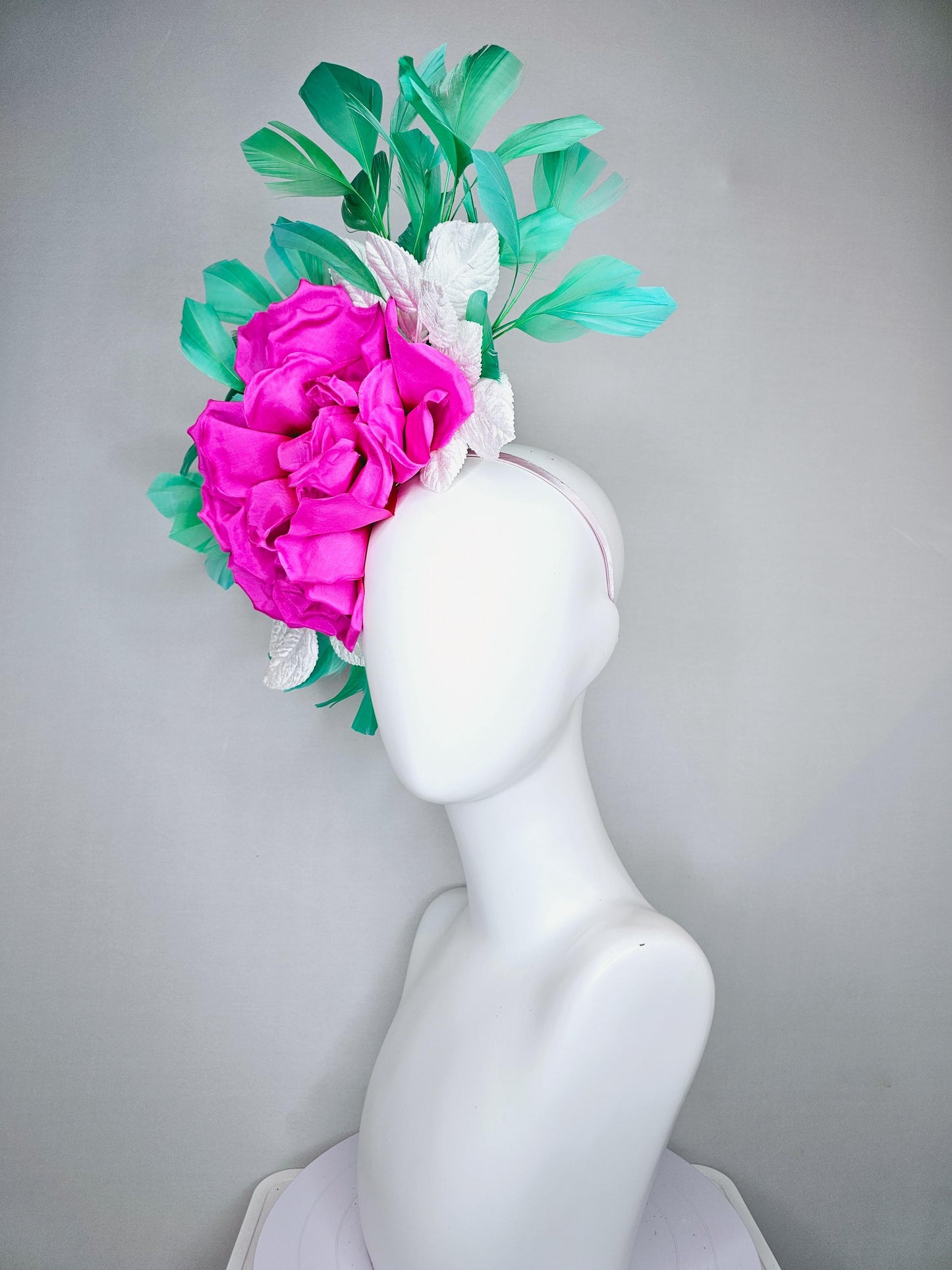 kentucky derby hat fascinator with bright pink fuchsia satin silk flower with white leaves and green branching feathers