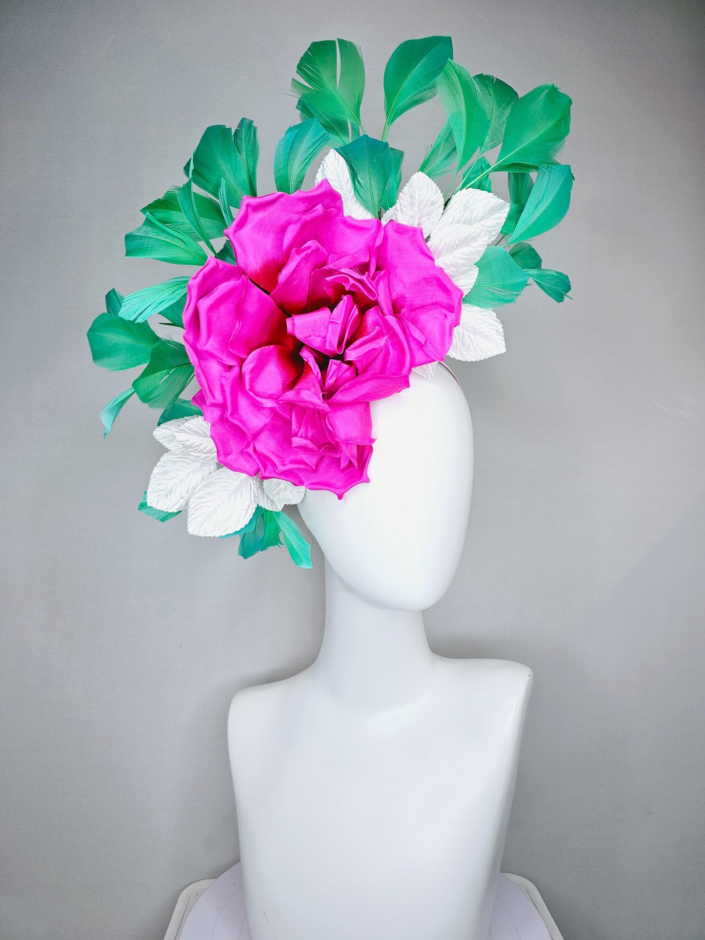 kentucky derby hat fascinator with bright pink fuchsia satin silk flower with white leaves and green branching feathers