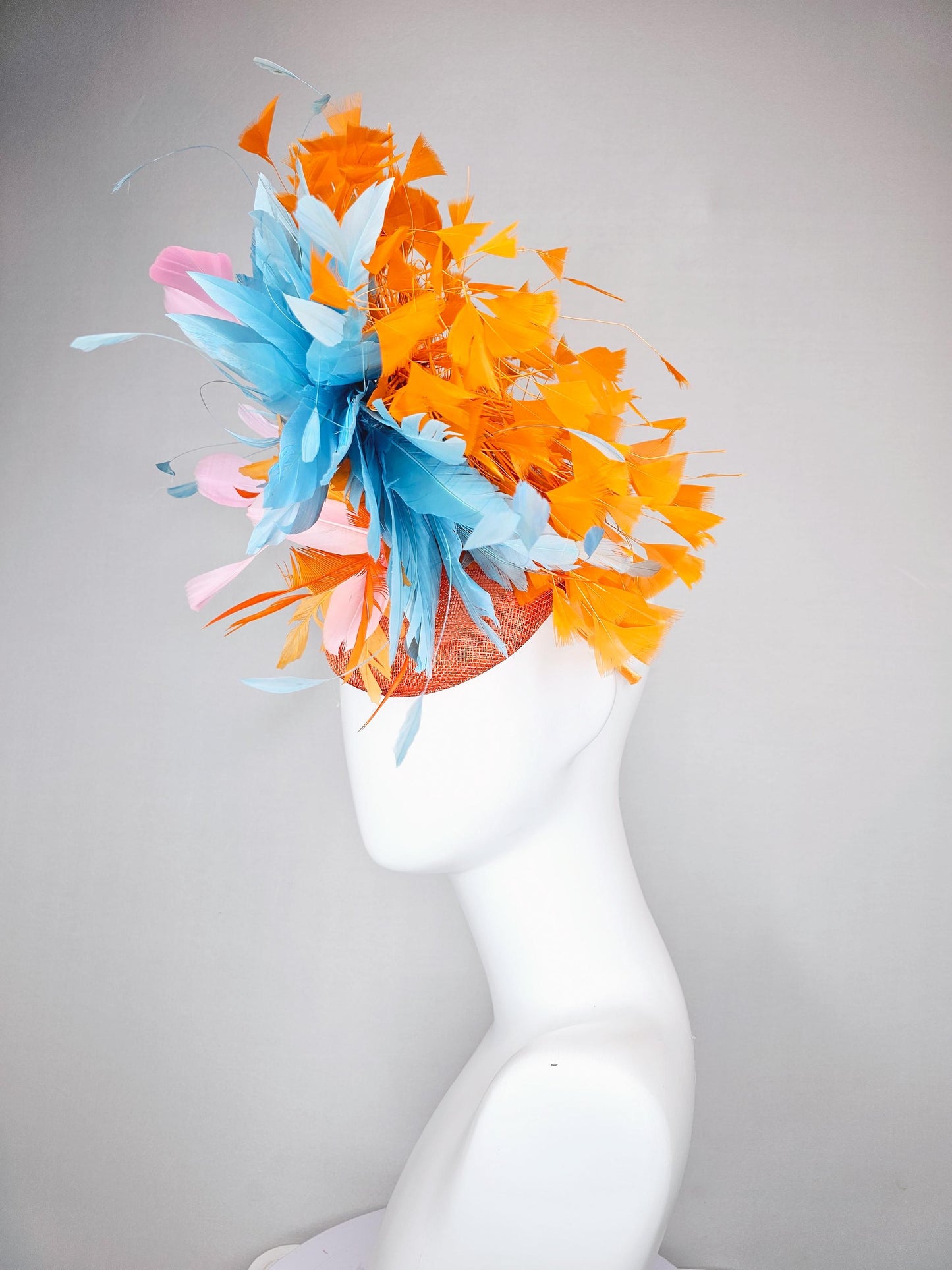 kentucky derby hat fascinator orange sinamay with bright orange, sky blue and light pink branching feathers