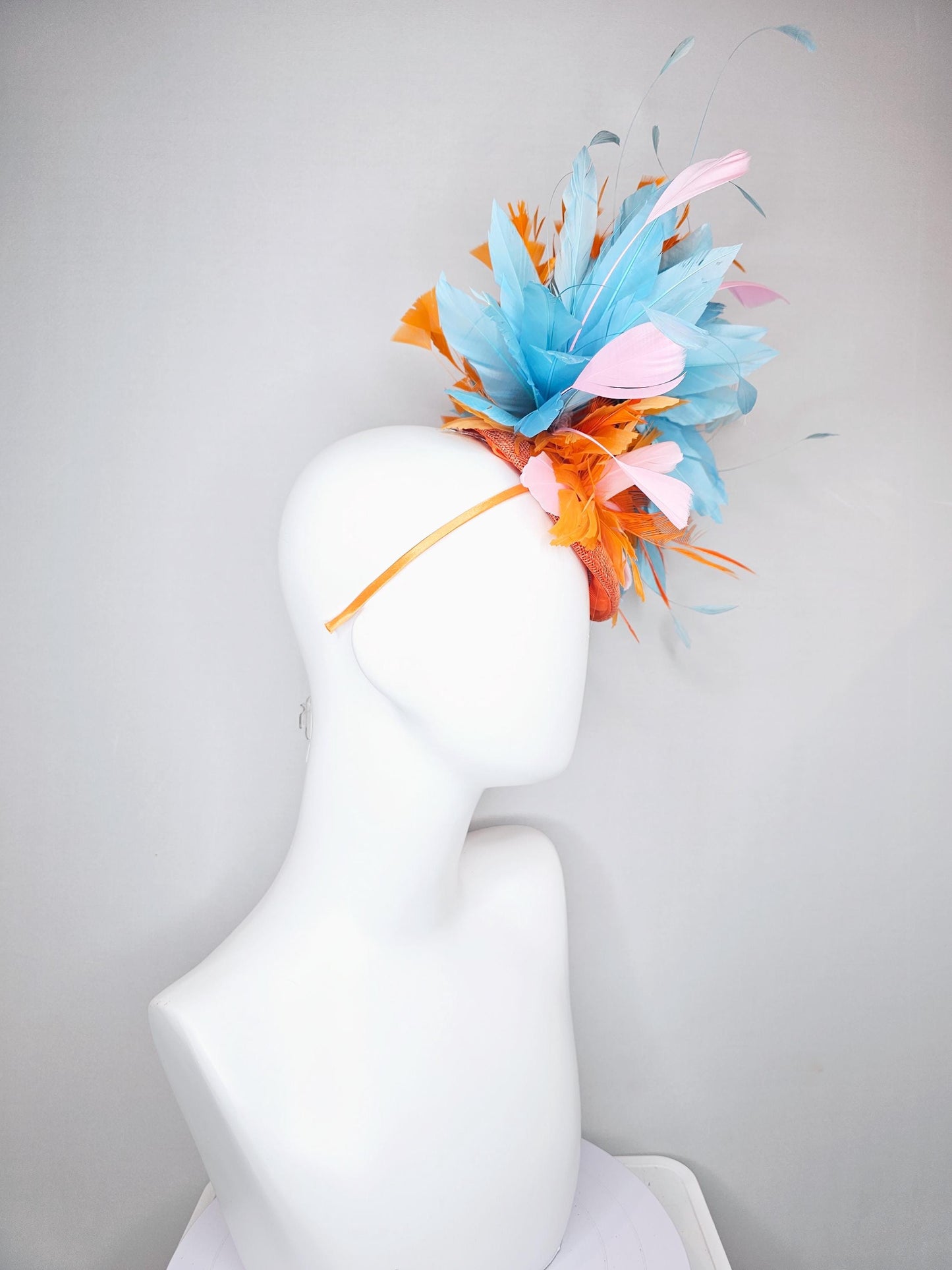 kentucky derby hat fascinator orange sinamay with bright orange, sky blue and light pink branching feathers