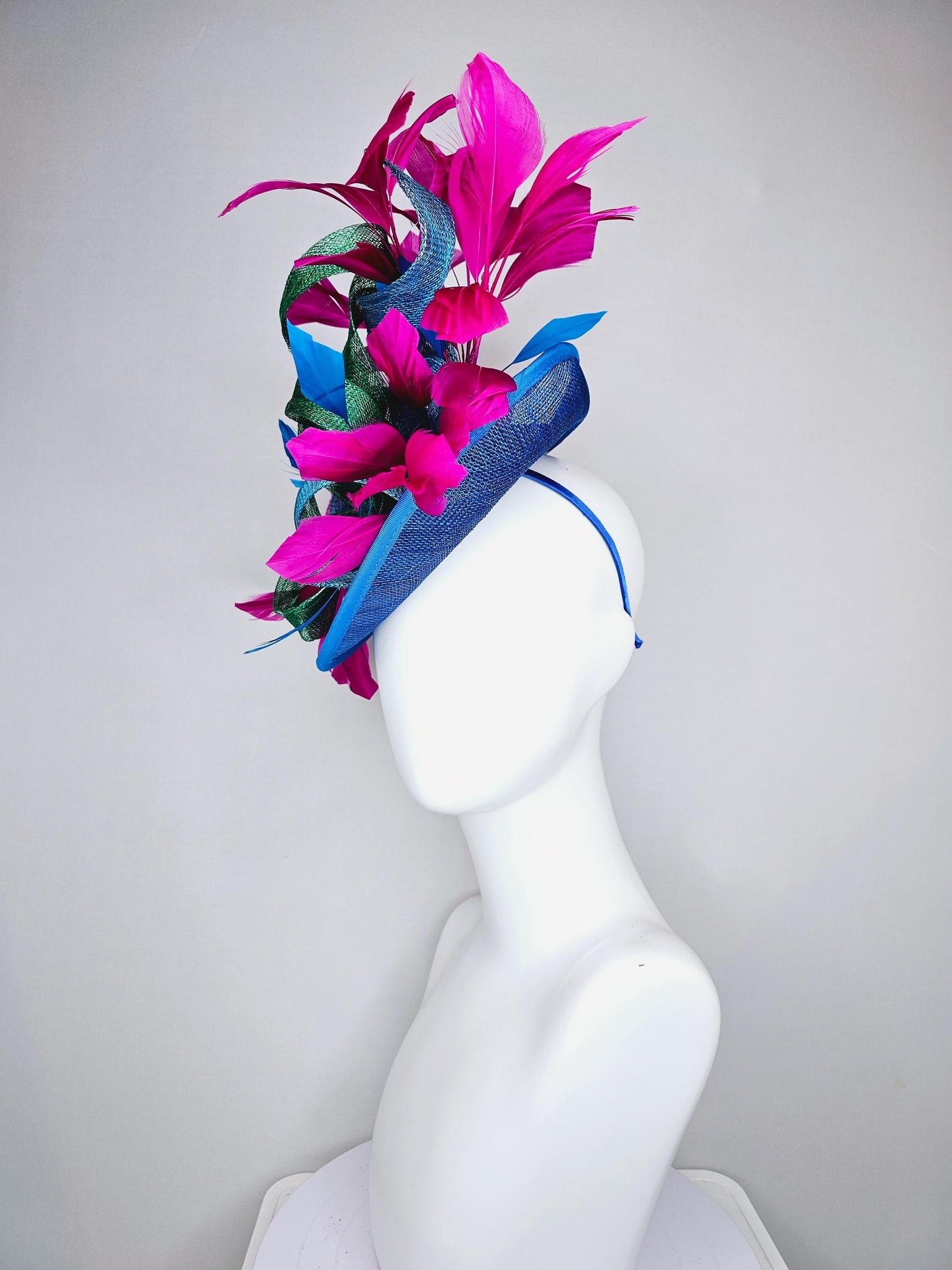 kentucky derby hat fascinator royal blue sinamay saucer with bright fuchsia hot pink branching feathers and green and blue sinamay curls