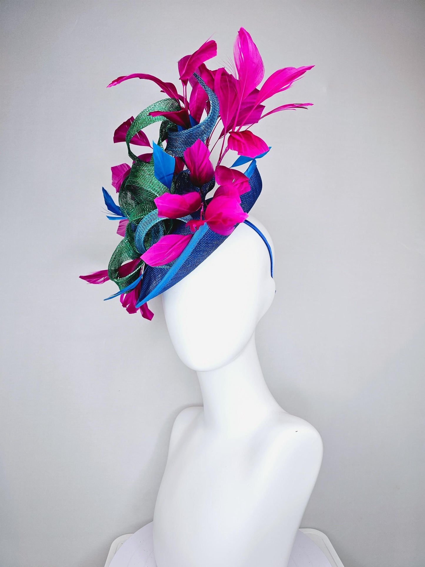 kentucky derby hat fascinator royal blue sinamay saucer with bright fuchsia hot pink branching feathers and green and blue sinamay curls