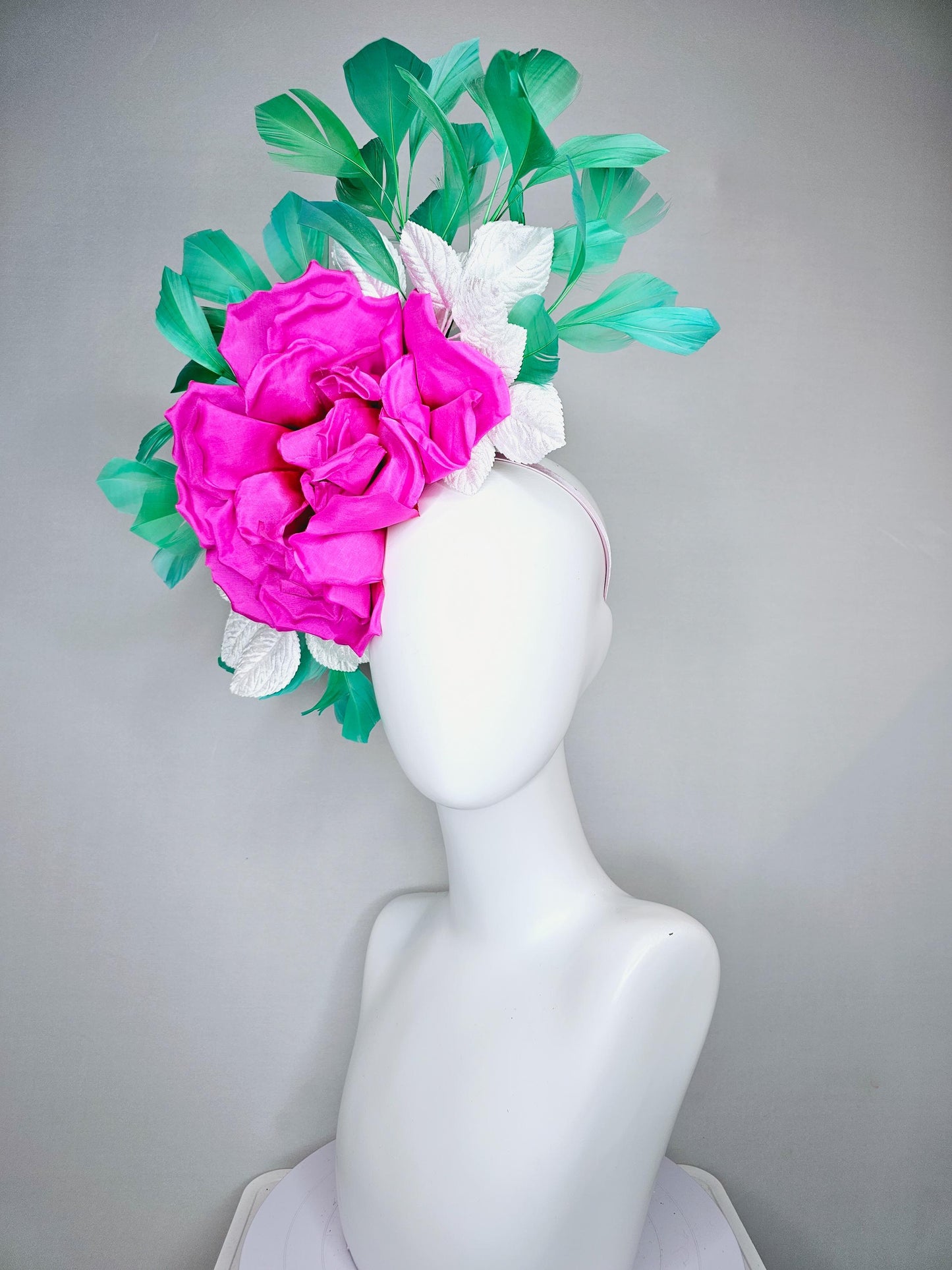 kentucky derby hat fascinator with bright pink fuchsia satin silk flower with white leaves and green branching feathers