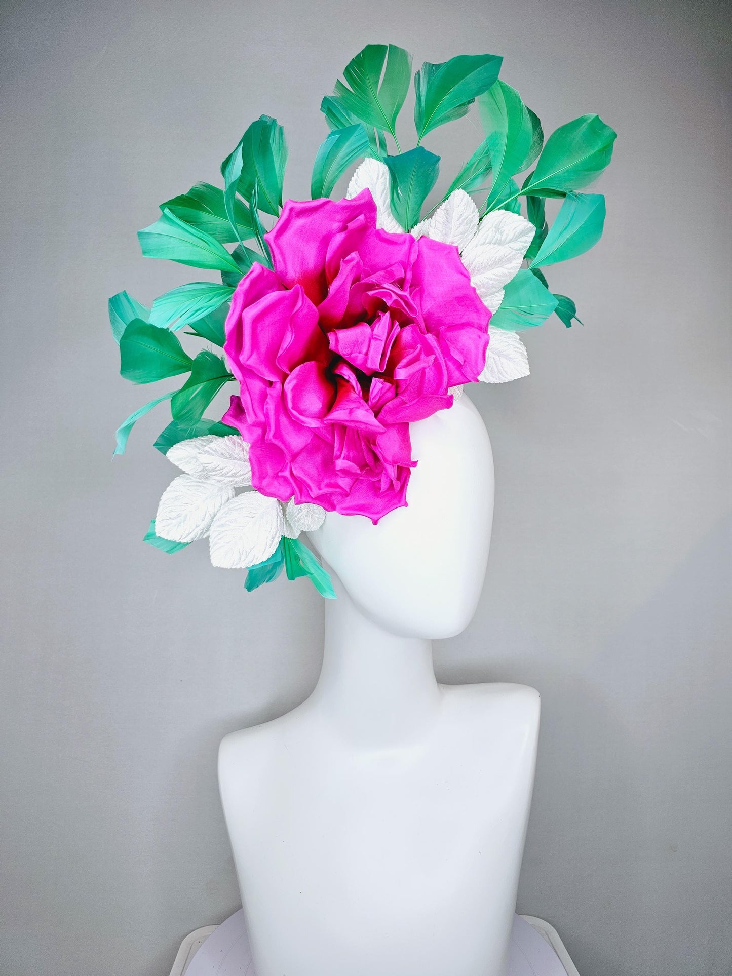 kentucky derby hat fascinator with bright pink fuchsia satin silk flower with white leaves and green branching feathers