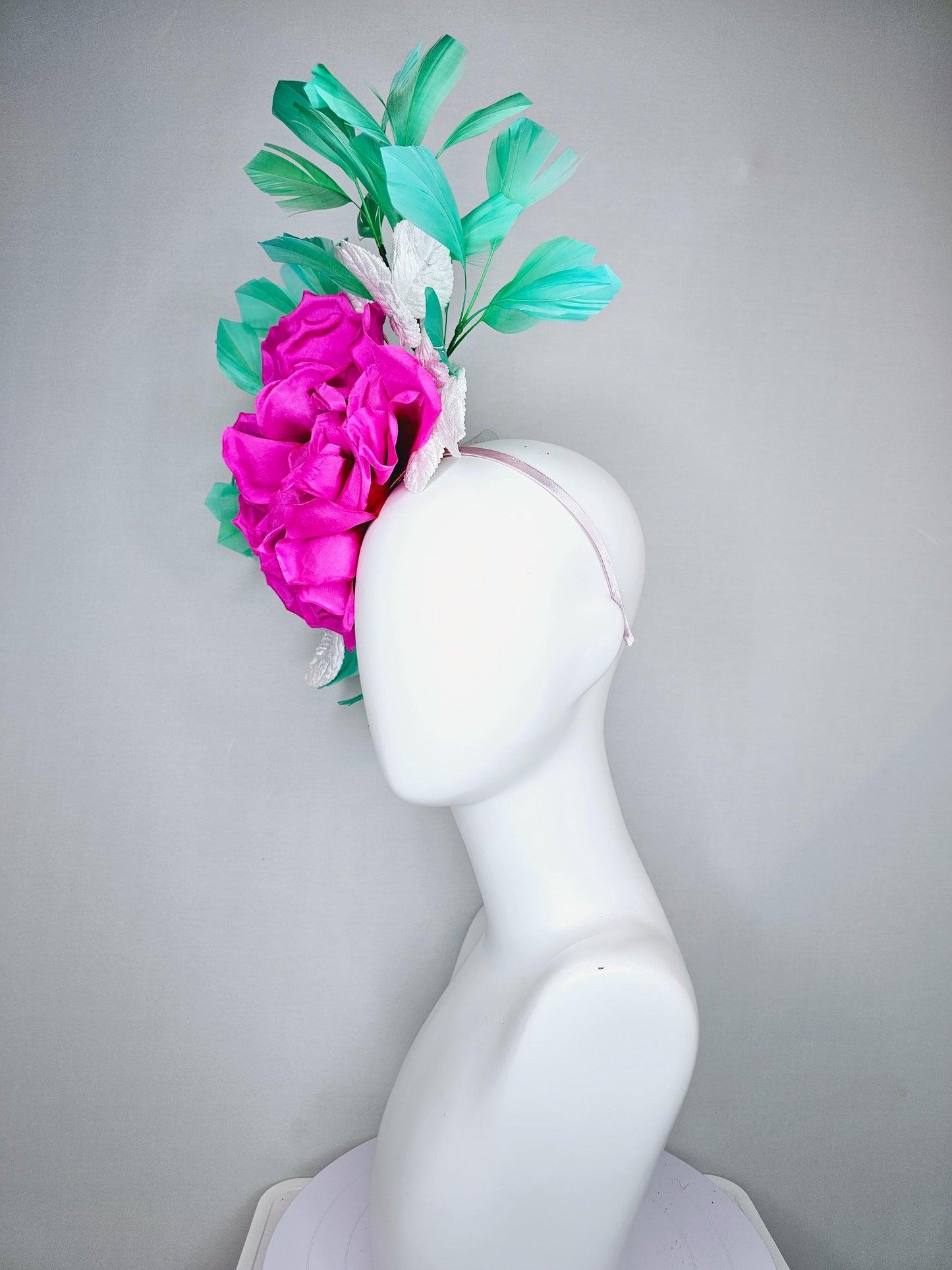 kentucky derby hat fascinator with bright pink fuchsia satin silk flower with white leaves and green branching feathers