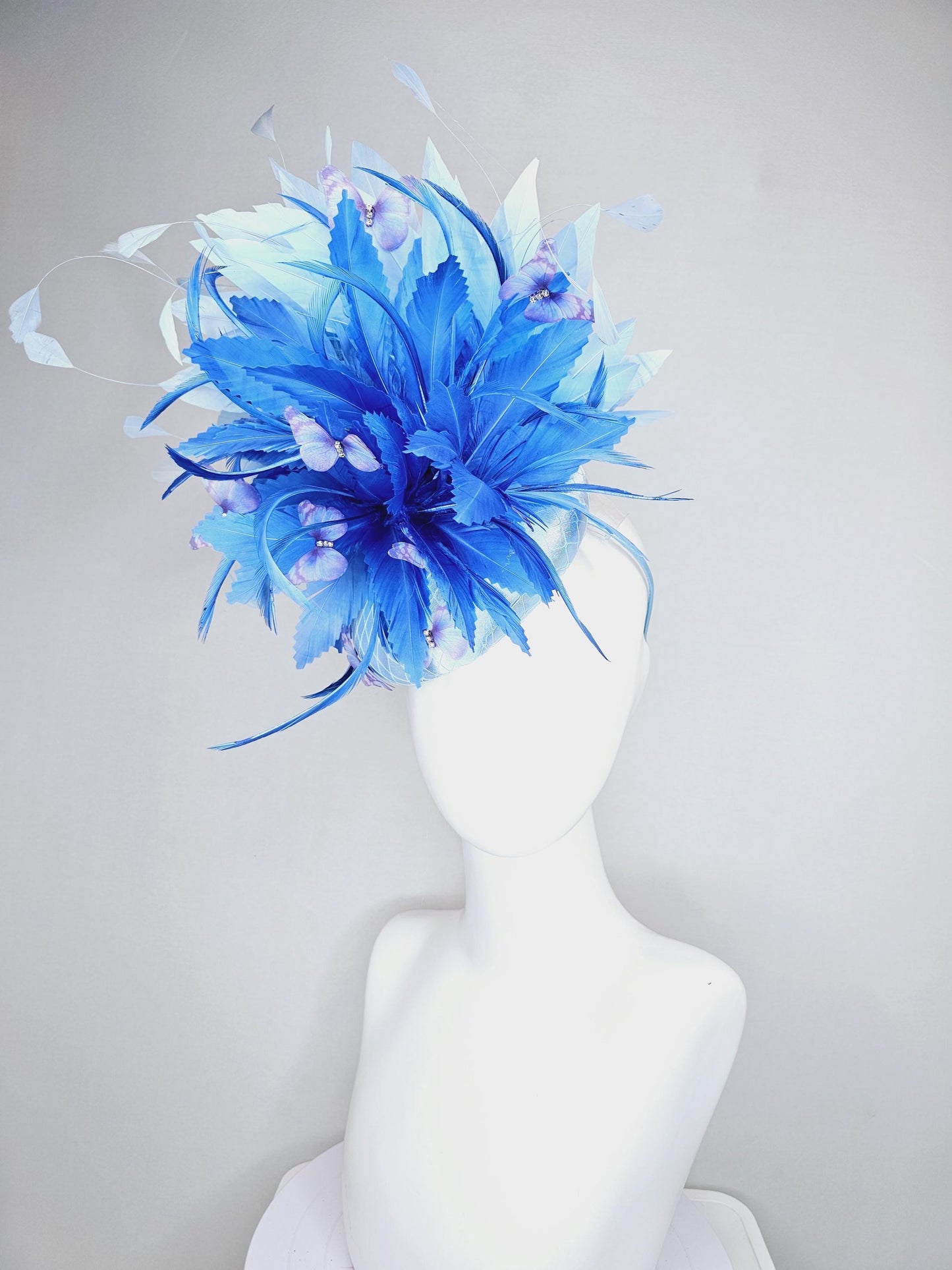 kentucky derby hat fascinator light blue satin with netting, fluffy zigzag royal blue and light blue branching feathers, purple butterflies