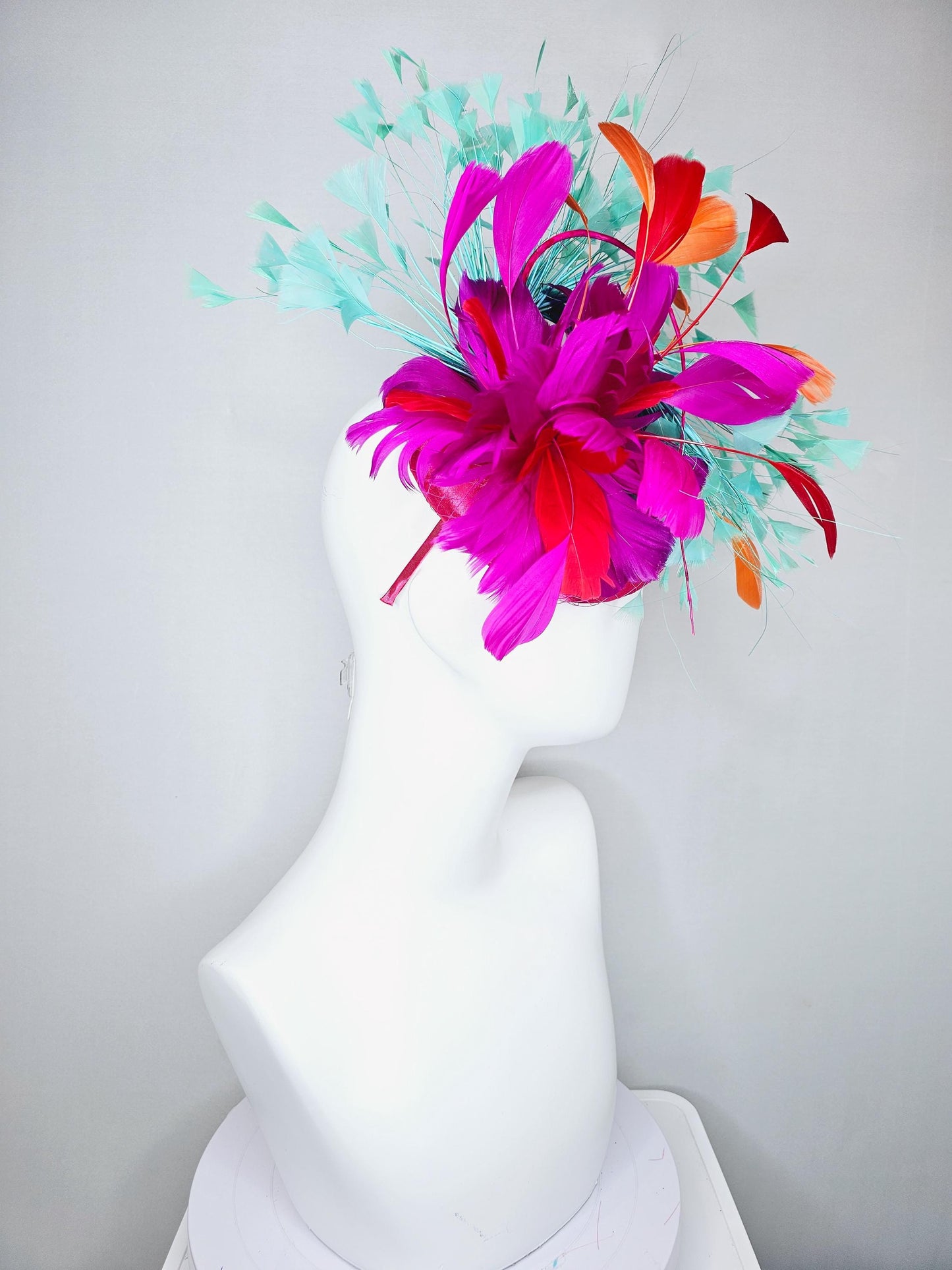 kentucky derby hat fascinator pink satin with netting and fluffy bright pink fuchsia, aqua blue green, red, orange coral branching feathers