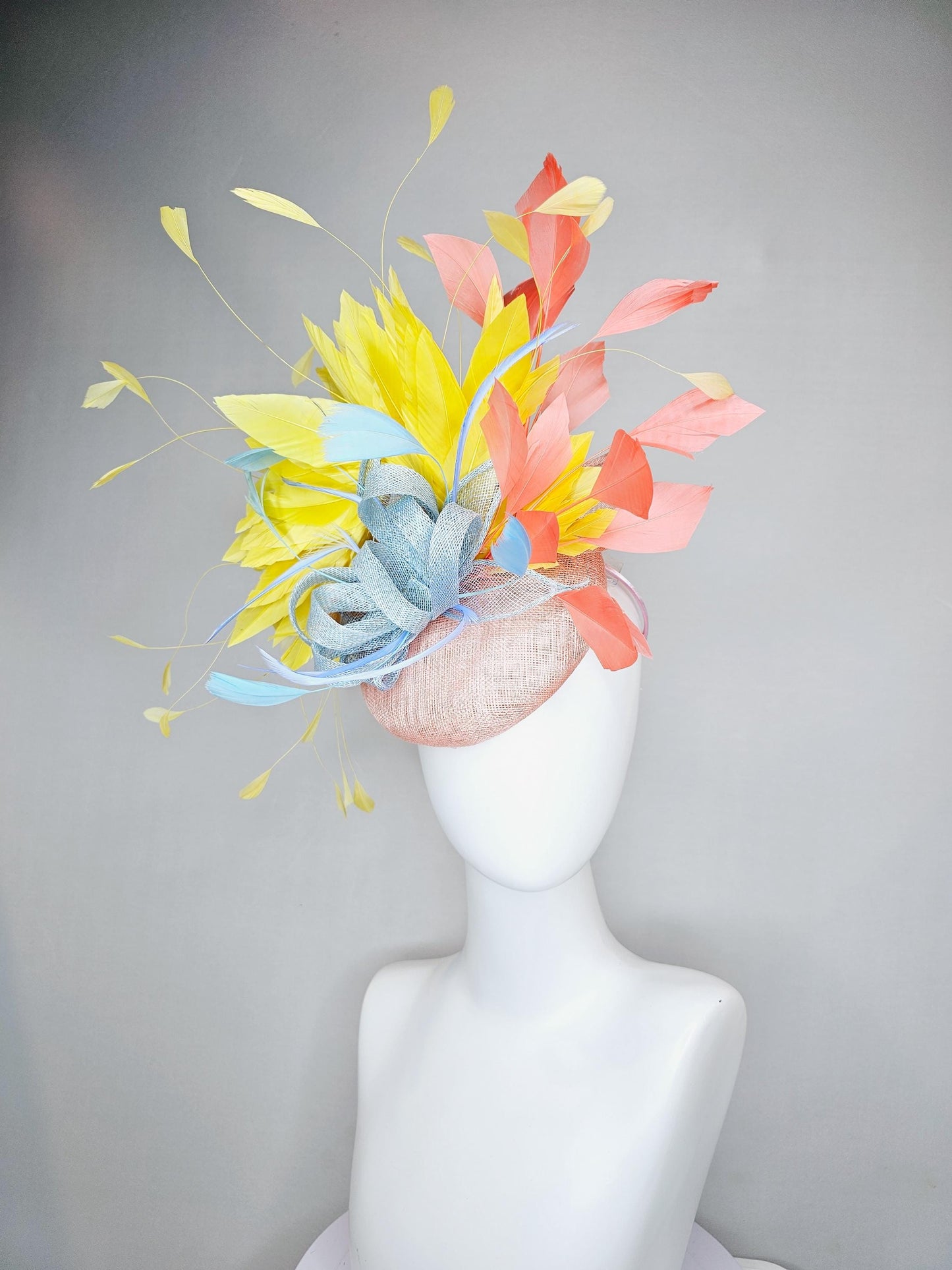 kentucky derby hat fascinator light pink sinamay with light blue sinamay bow and blue feathers, coral orange and yellow branching feathers