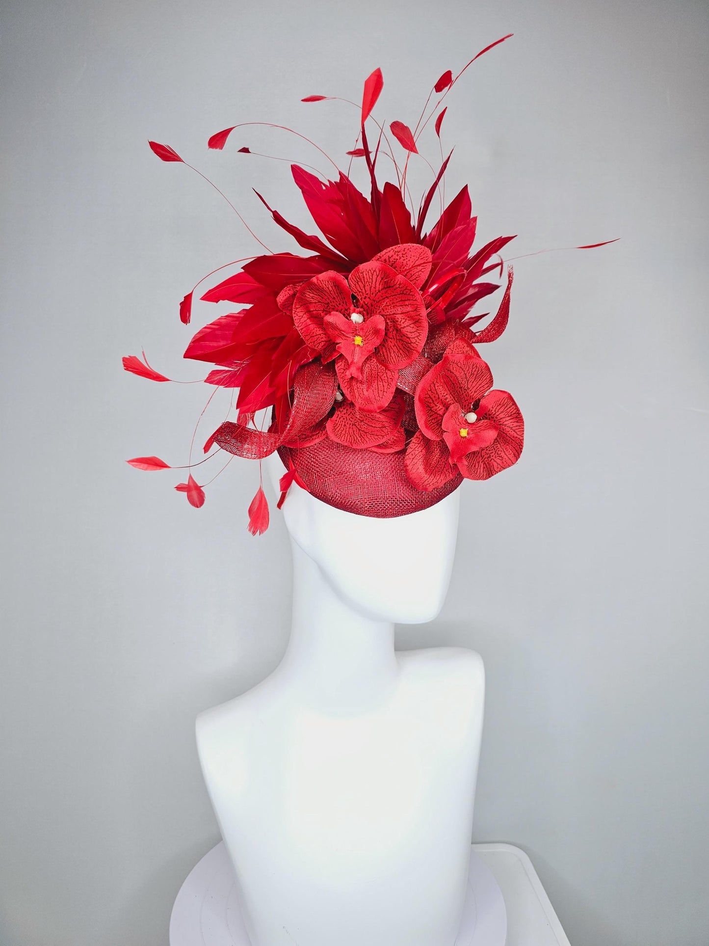 kentucky derby hat fascinator scarlet red sinamay with curls and cherry red branching feathers with large red orchid flowers