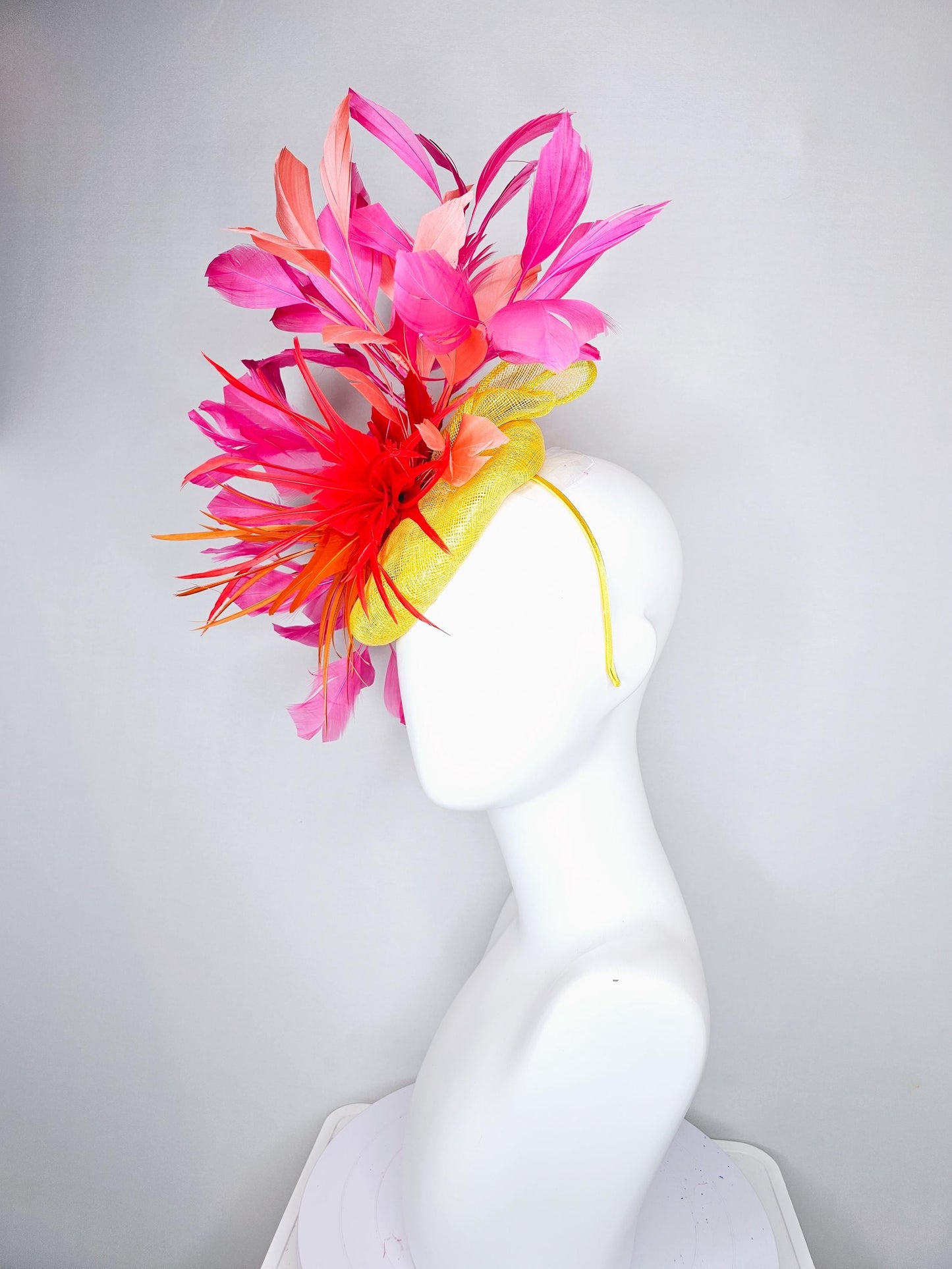 kentucky derby hat fascinator yellow sinamay and curls with bright red feather flower with branching orange, coral, peach and pink feathers