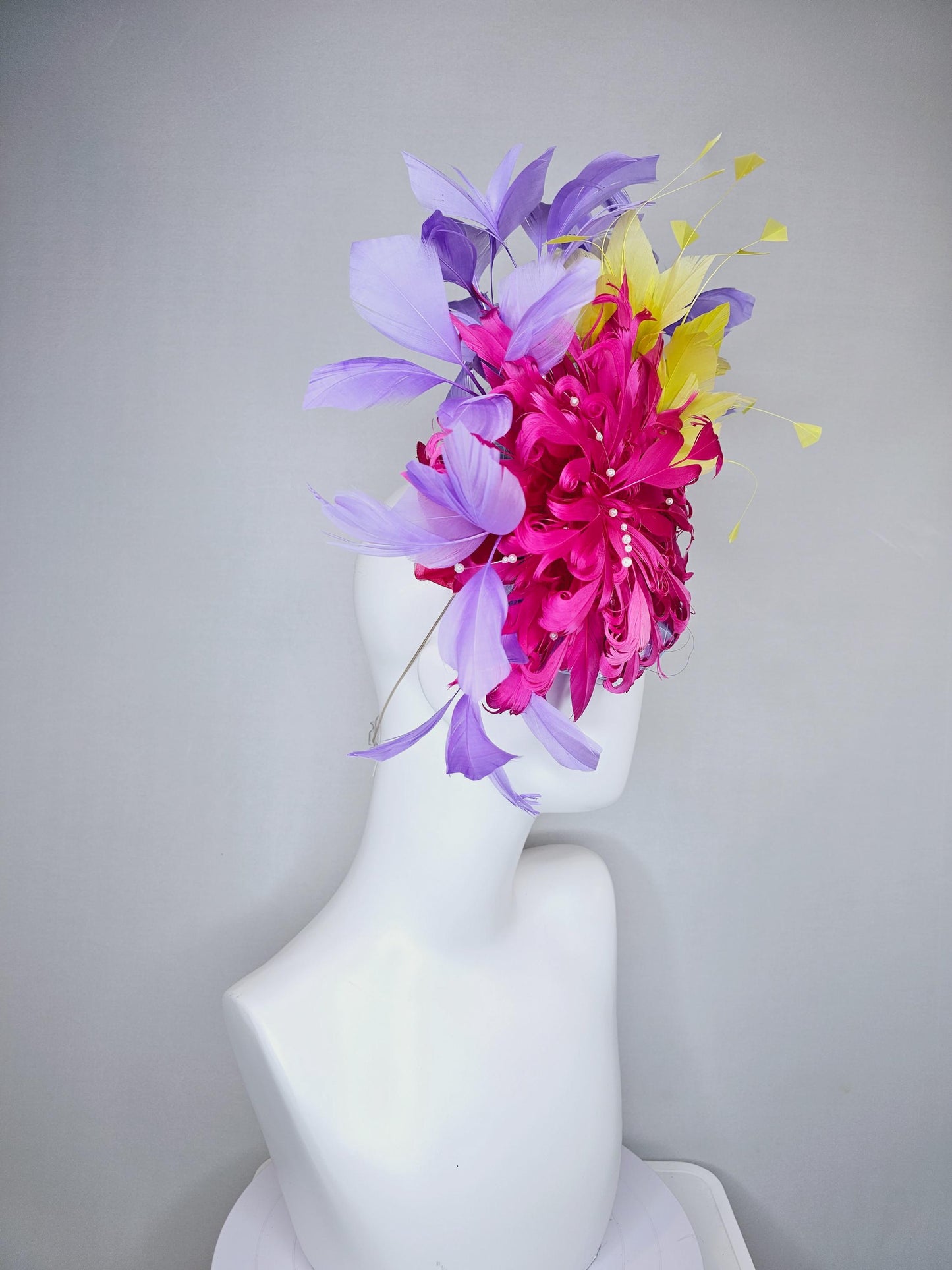 kentucky derby hat fascinator light blue satin with netting, bright pink curly feather flower, yellow and lavender purple branching feathers
