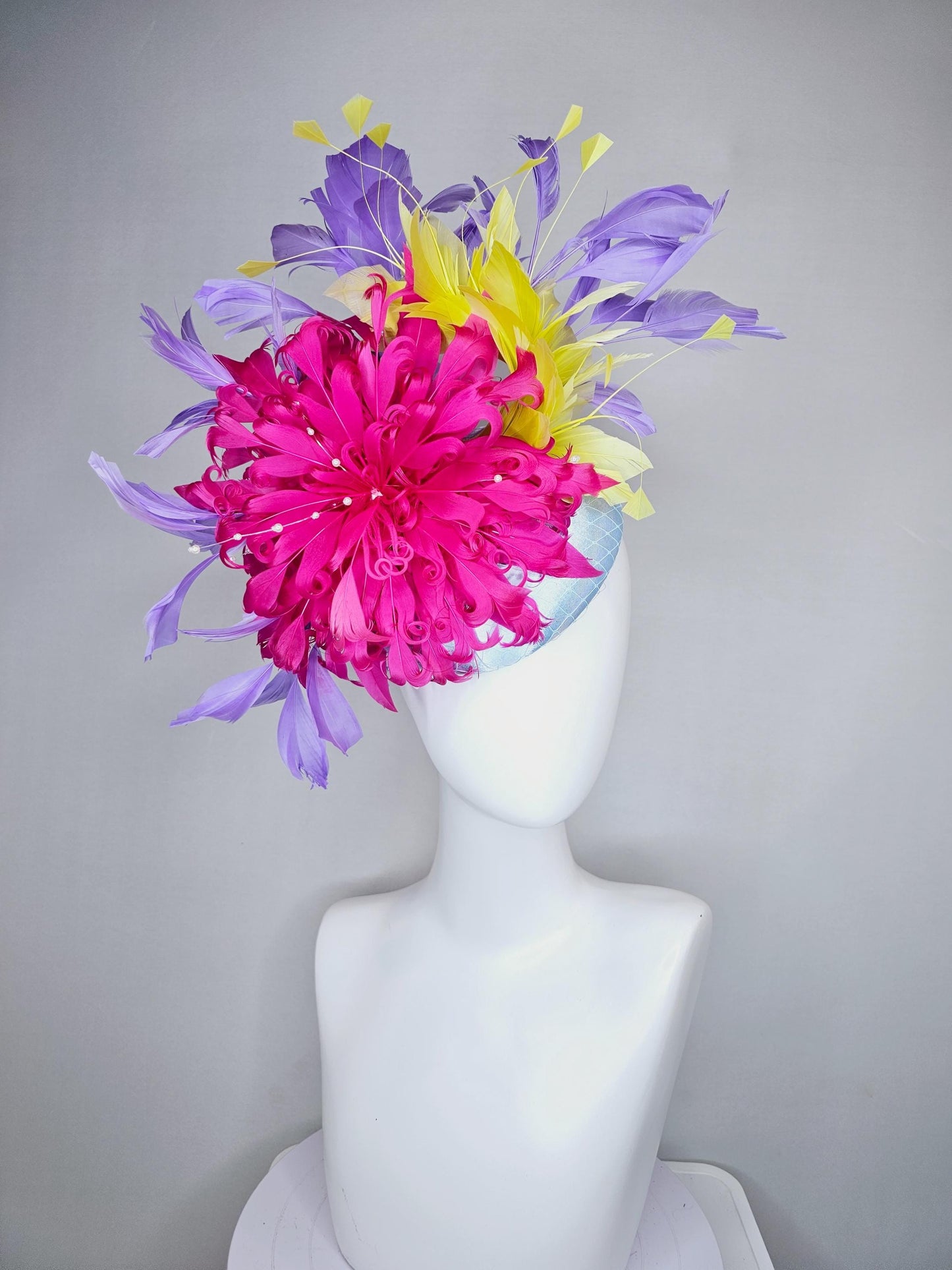 kentucky derby hat fascinator light blue satin with netting, bright pink curly feather flower, yellow and lavender purple branching feathers