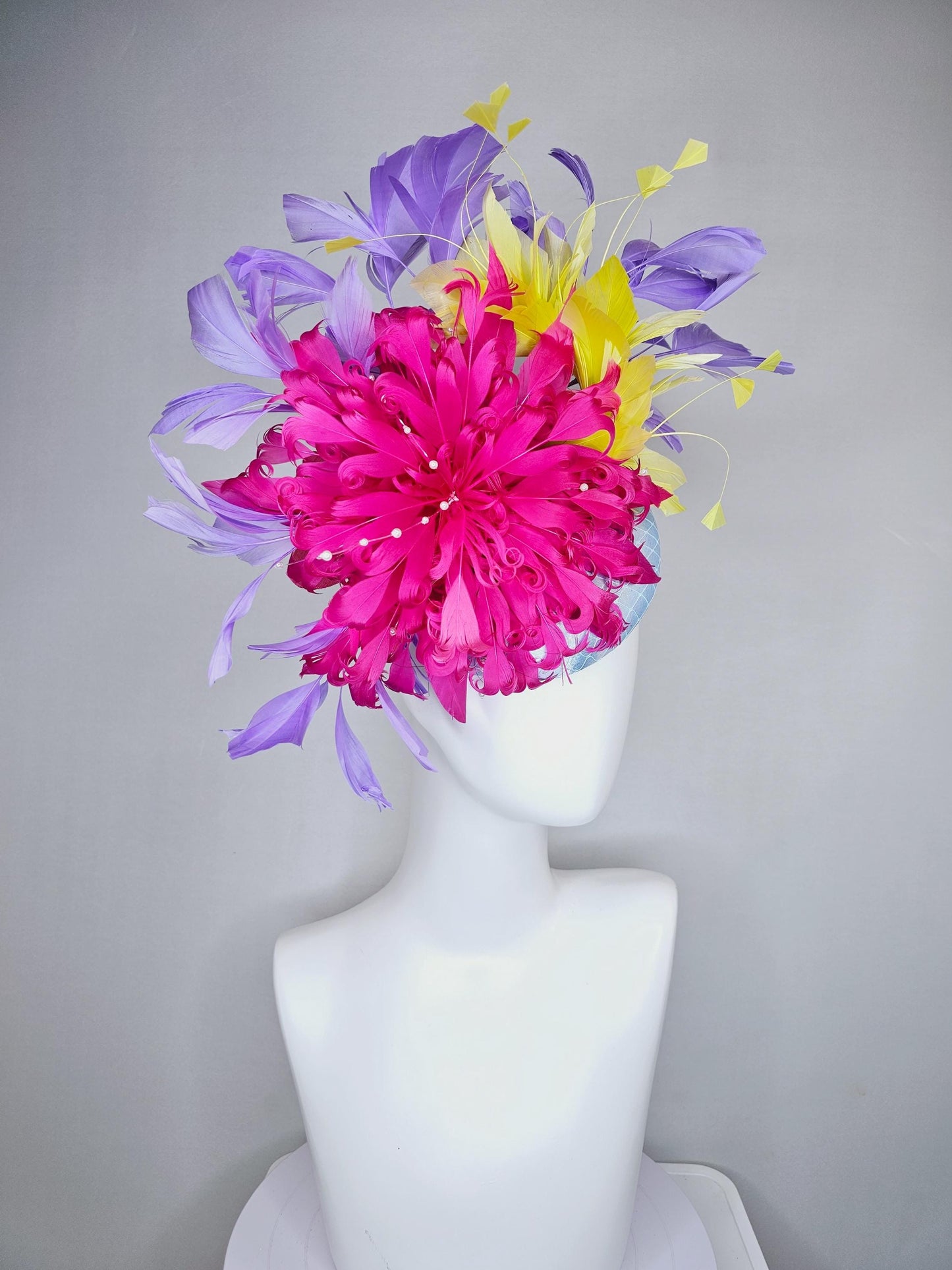 kentucky derby hat fascinator light blue satin with netting, bright pink curly feather flower, yellow and lavender purple branching feathers