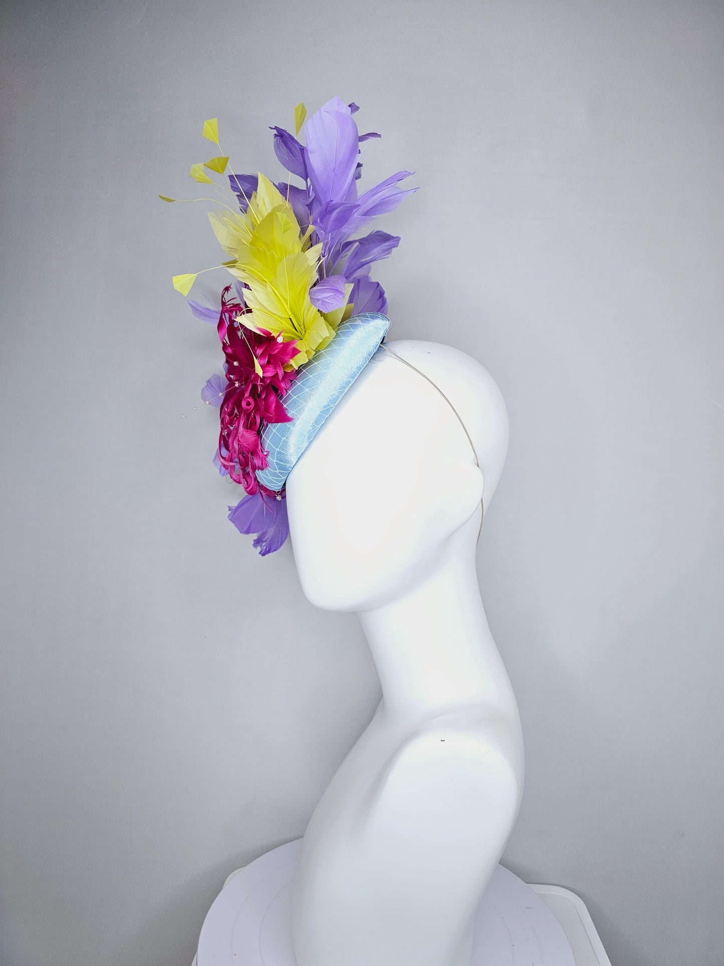 kentucky derby hat fascinator light blue satin with netting, bright pink curly feather flower, yellow and lavender purple branching feathers