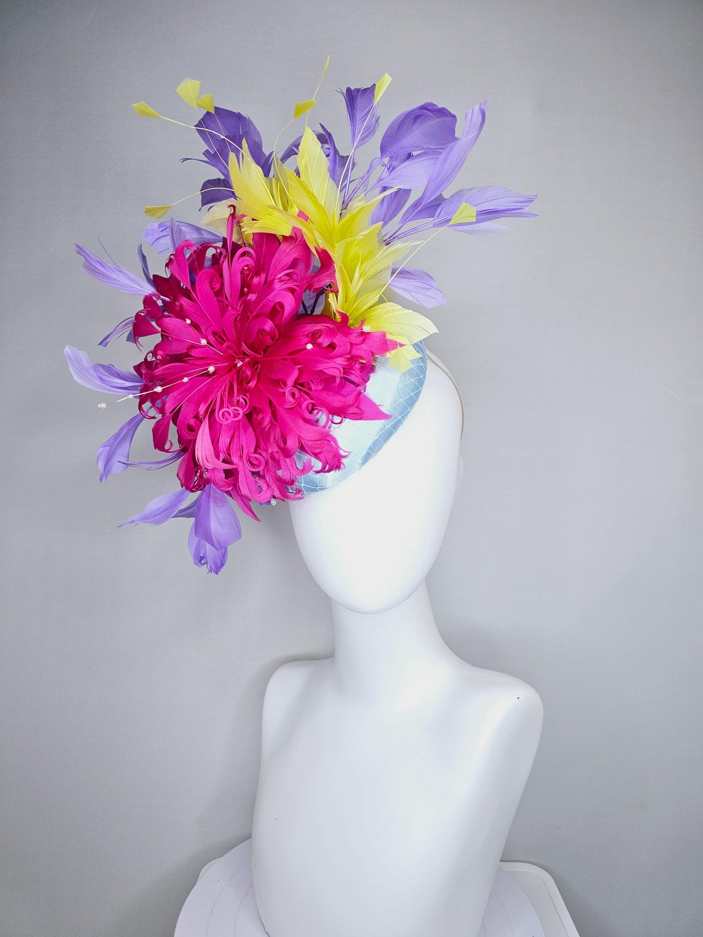 kentucky derby hat fascinator light blue satin with netting, bright pink curly feather flower, yellow and lavender purple branching feathers