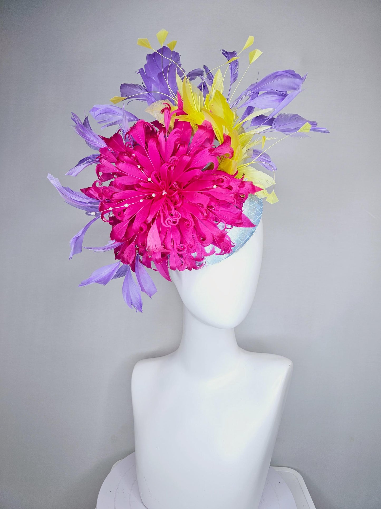 kentucky derby hat fascinator light blue satin with netting, bright pink curly feather flower, yellow and lavender purple branching feathers