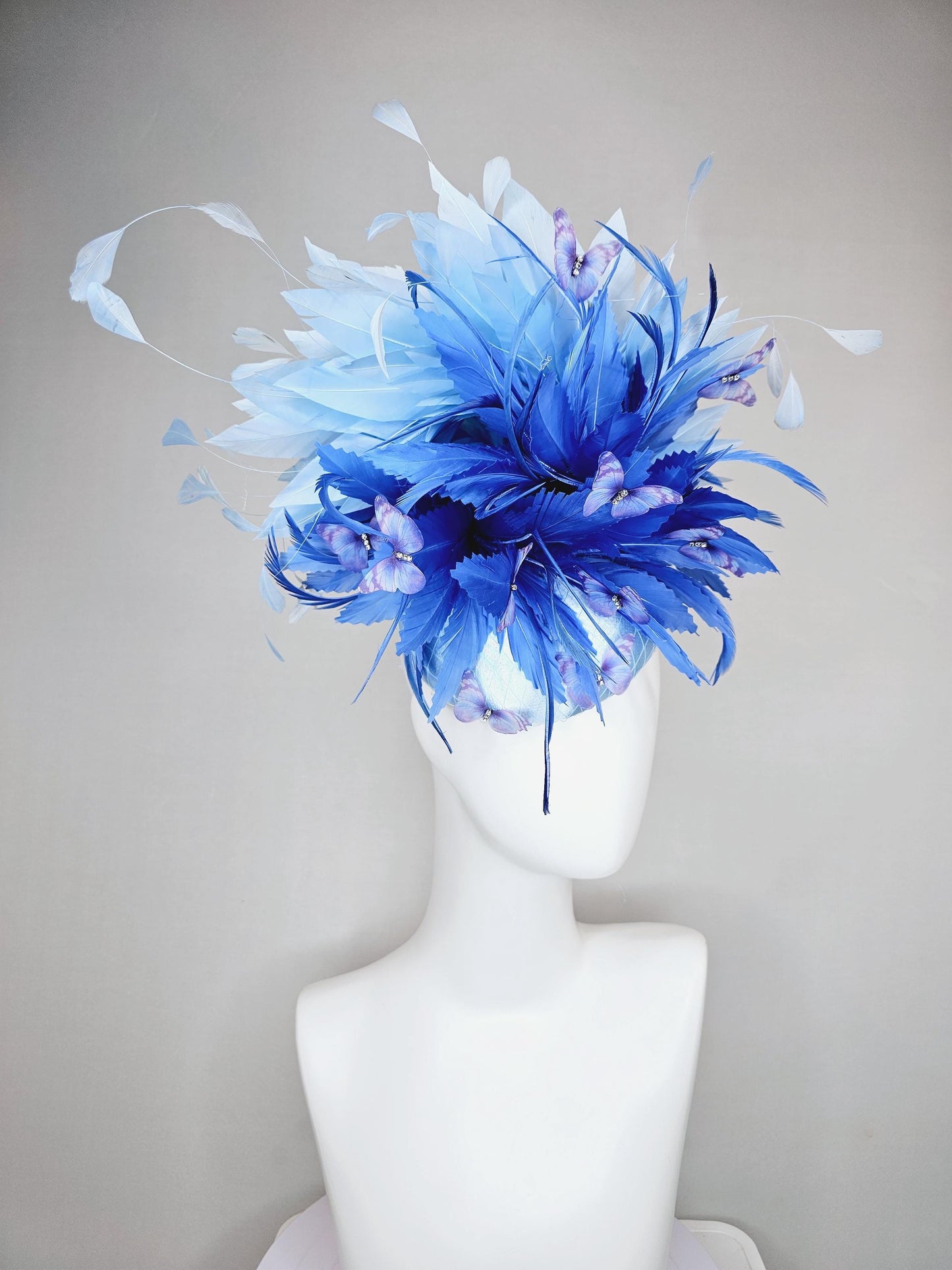 kentucky derby hat fascinator light blue satin with netting, fluffy zigzag royal blue and light blue branching feathers, purple butterflies