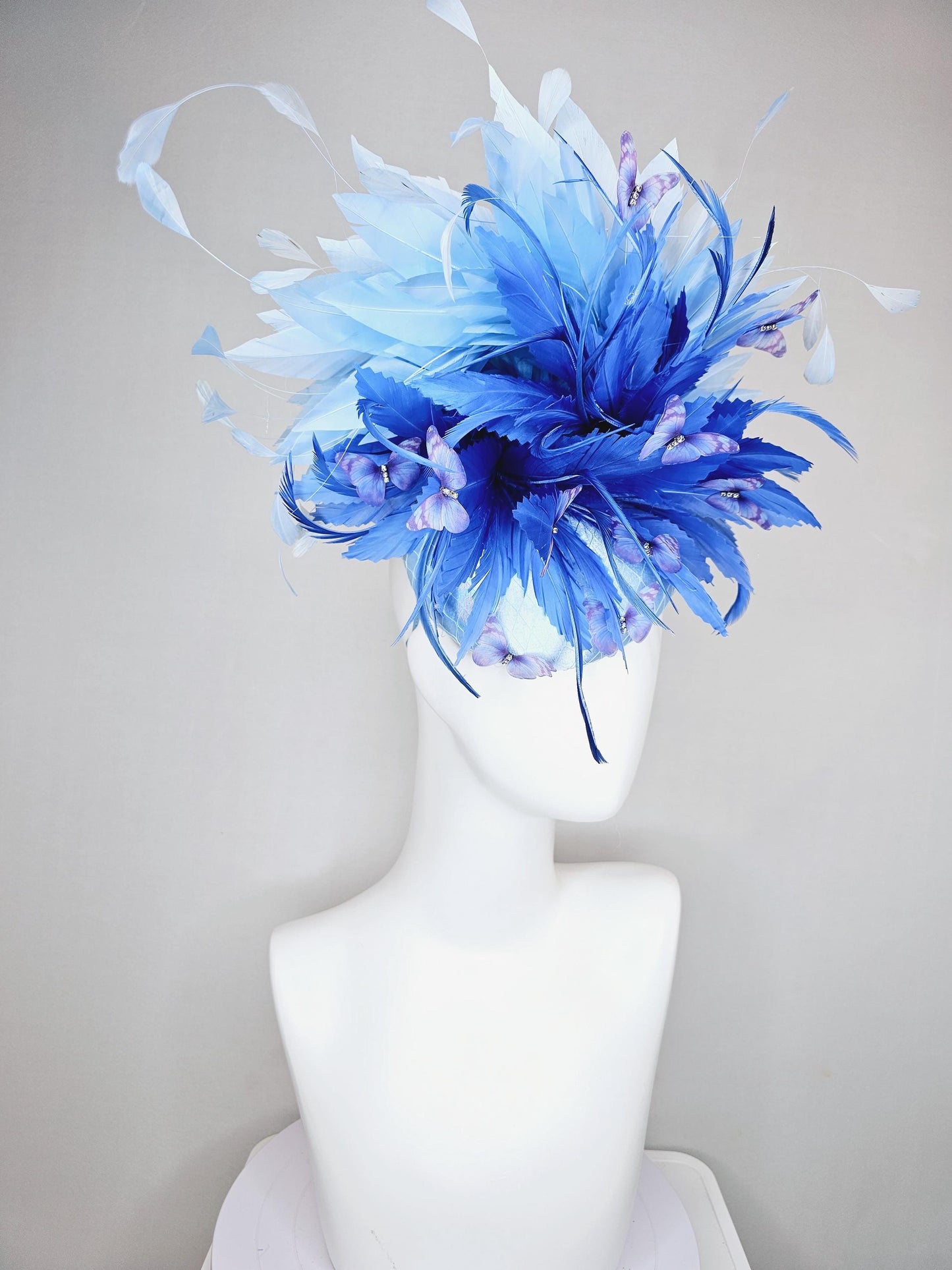 kentucky derby hat fascinator light blue satin with netting, fluffy zigzag royal blue and light blue branching feathers, purple butterflies
