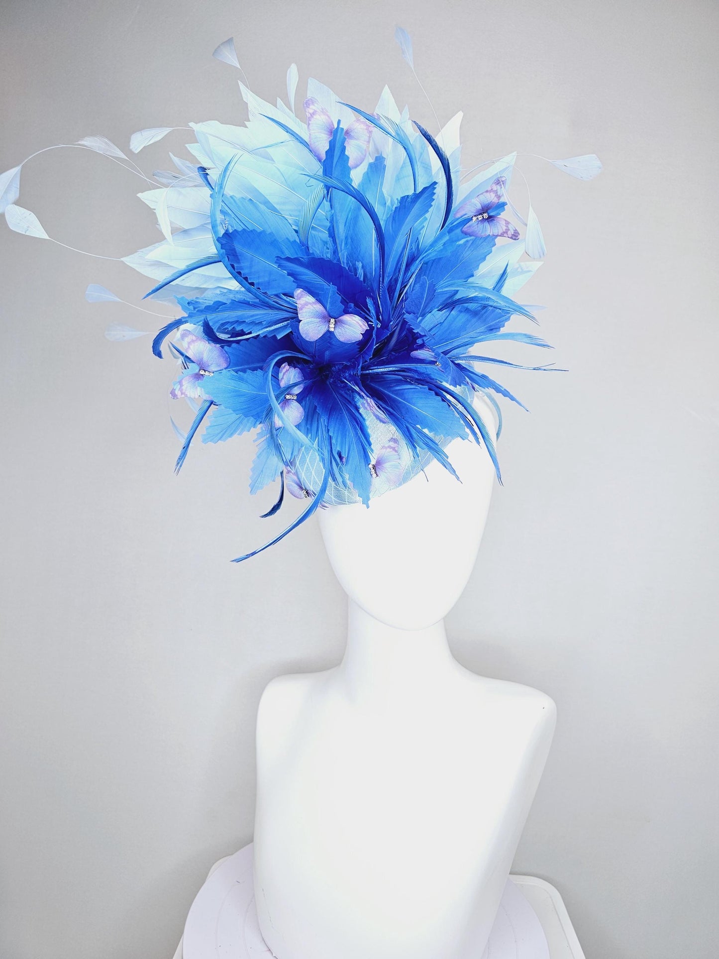 kentucky derby hat fascinator light blue satin with netting, fluffy zigzag royal blue and light blue branching feathers, purple butterflies