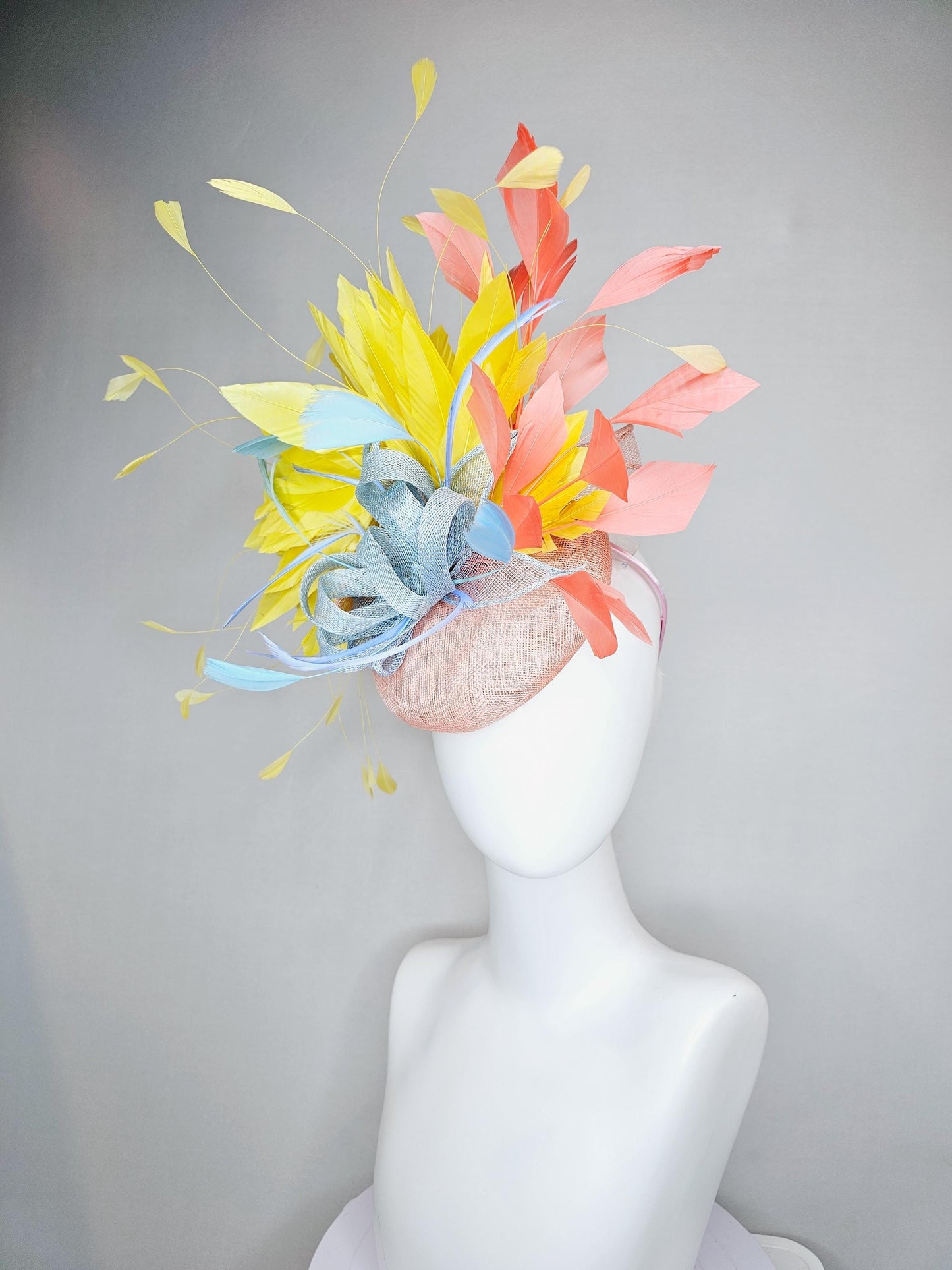 kentucky derby hat fascinator light pink sinamay with light blue sinamay bow and blue feathers, coral orange and yellow branching feathers