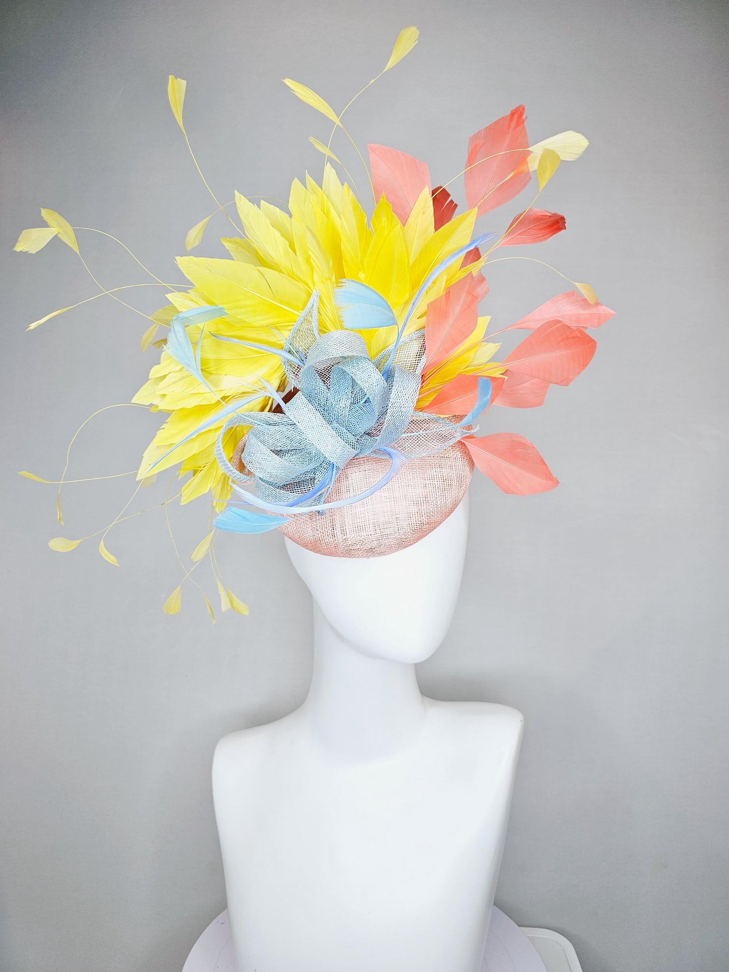 kentucky derby hat fascinator light pink sinamay with light blue sinamay bow and blue feathers, coral orange and yellow branching feathers