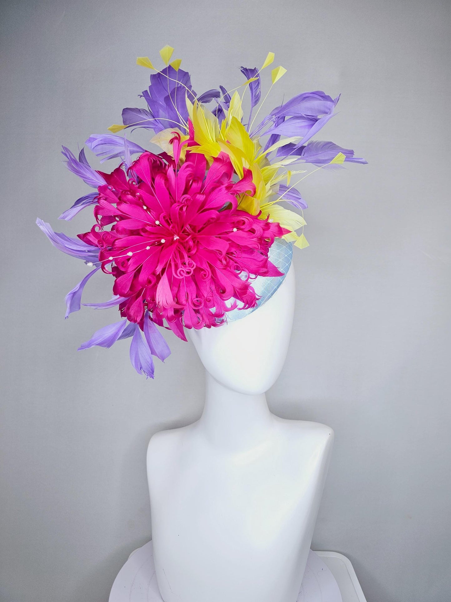 kentucky derby hat fascinator light blue satin with netting, bright pink curly feather flower, yellow and lavender purple branching feathers