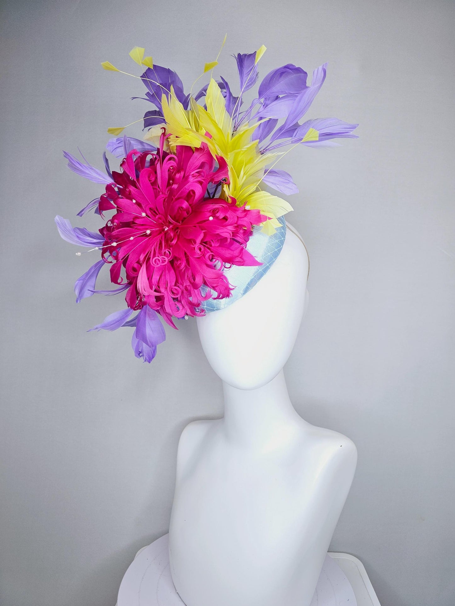 kentucky derby hat fascinator light blue satin with netting, bright pink curly feather flower, yellow and lavender purple branching feathers