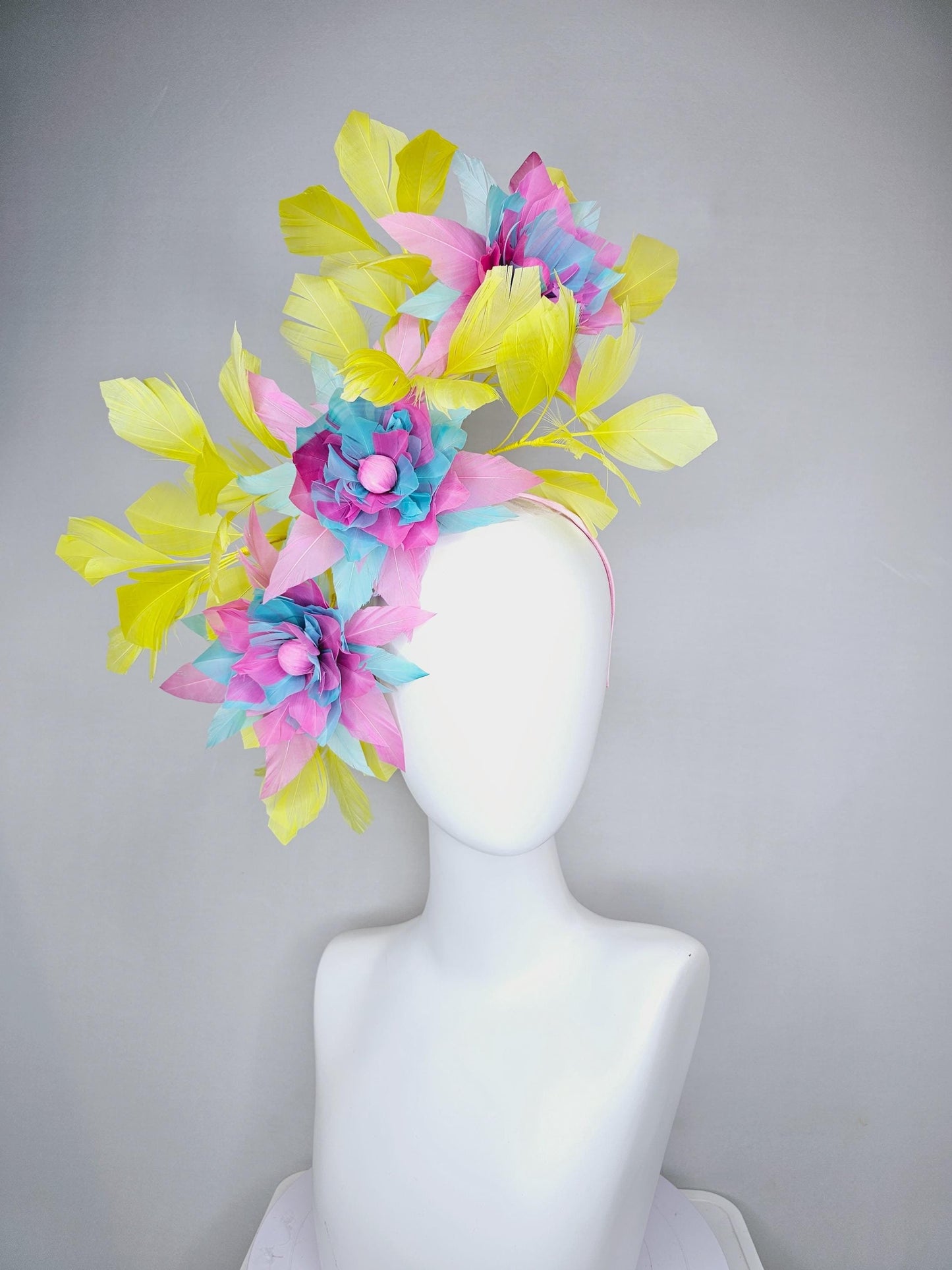 kentucky derby hat fascinator with large blush pink and baby sky blue feather flowers and yellow branching feathers