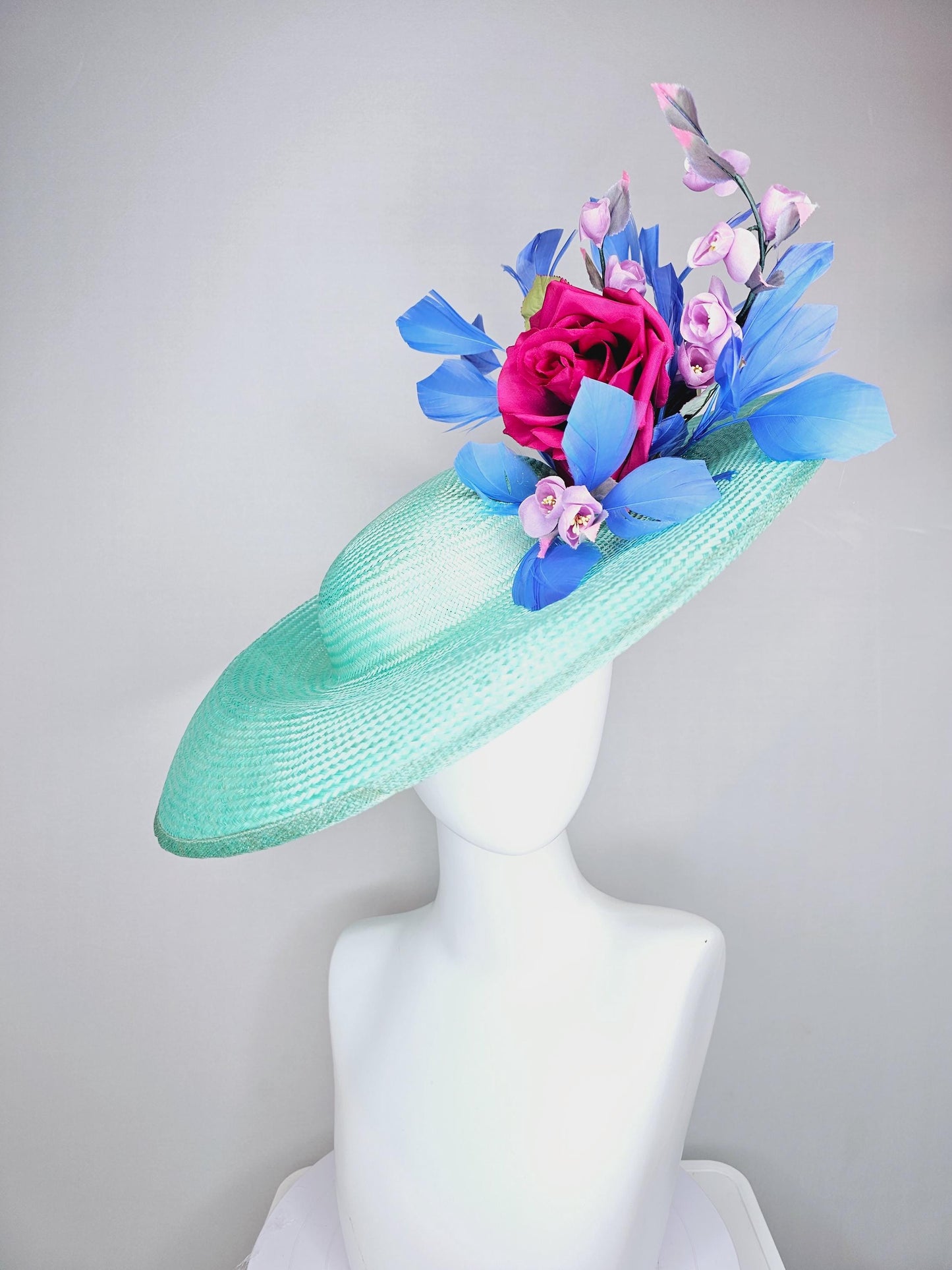 kentucky derby hat wide brim straw in aqua mint green with pink satin rose and lilac lavender purple satin rose stems cobalt blue feathers