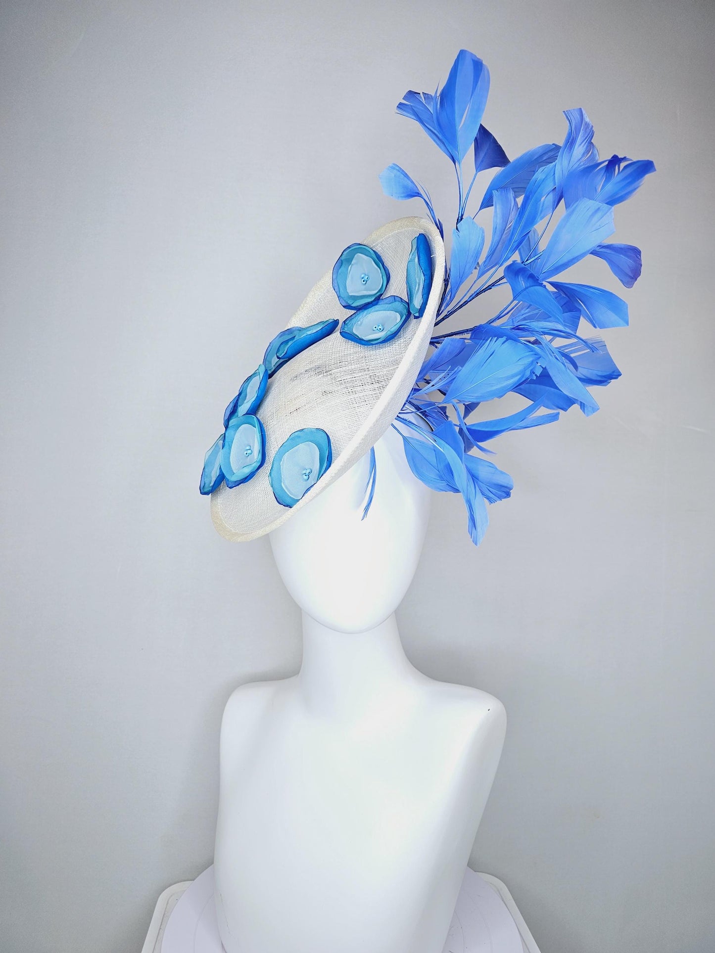 kentucky derby hat fascinator white sinamay saucer with light blue sky blue cobalt blue organza silk flowers, cobalt blue branching feathers