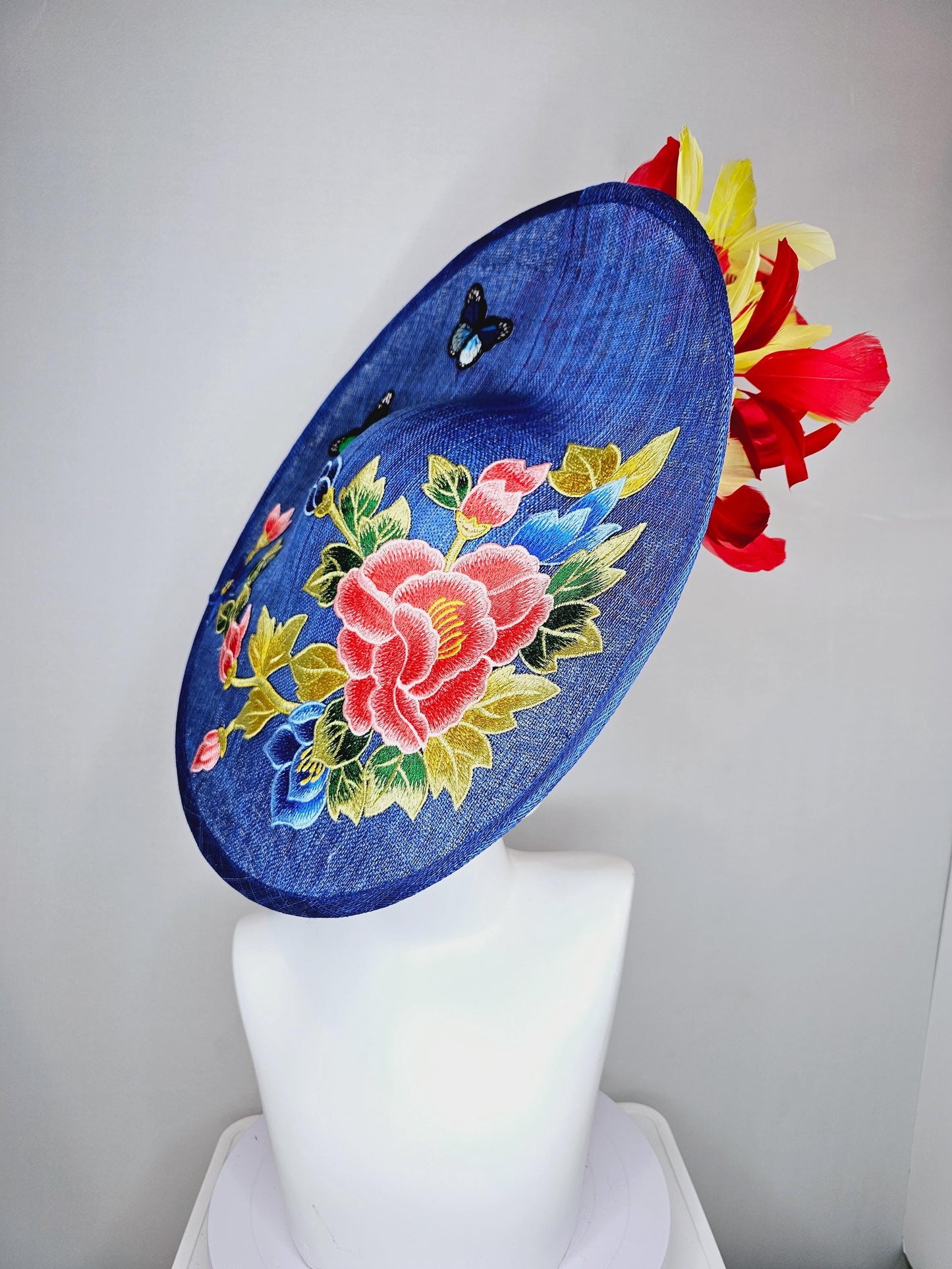 kentucky derby hat fascinator large blue sinamay saucer with red blue green yellow embroidered flowers and butterflies, red yellow feathers