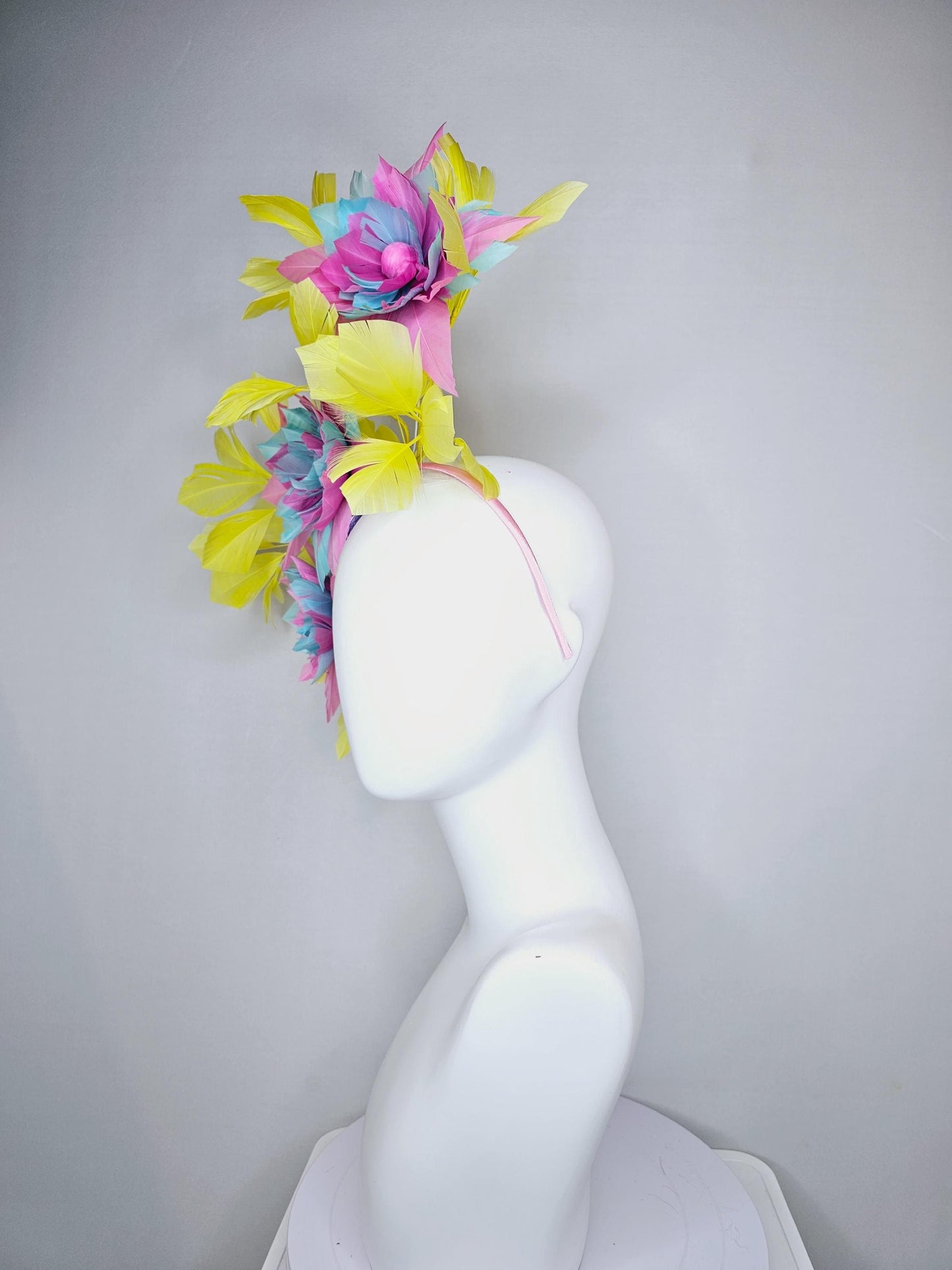 kentucky derby hat fascinator with large blush pink and baby sky blue feather flowers and yellow branching feathers