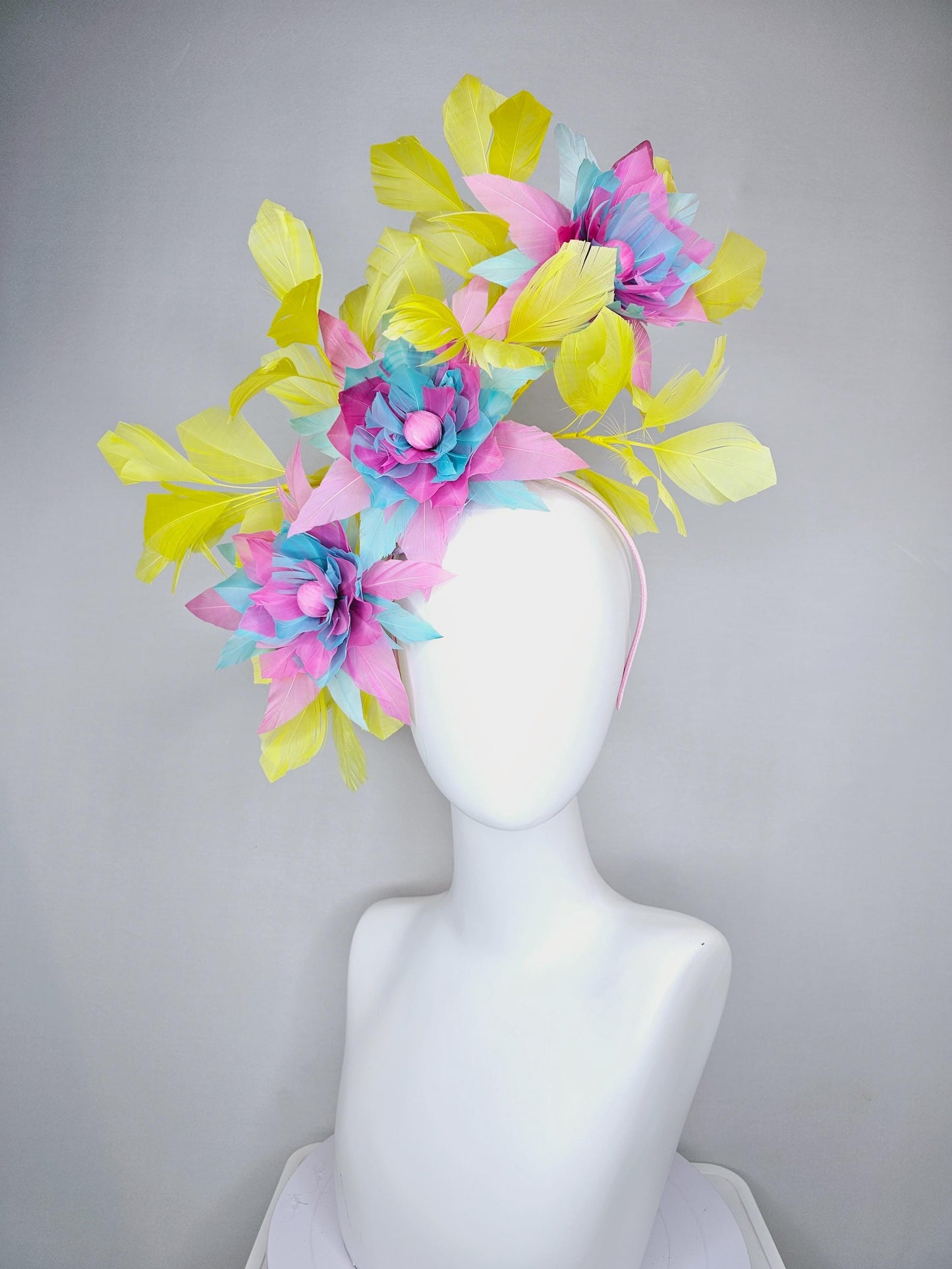 kentucky derby hat fascinator with large blush pink and baby sky blue feather flowers and yellow branching feathers